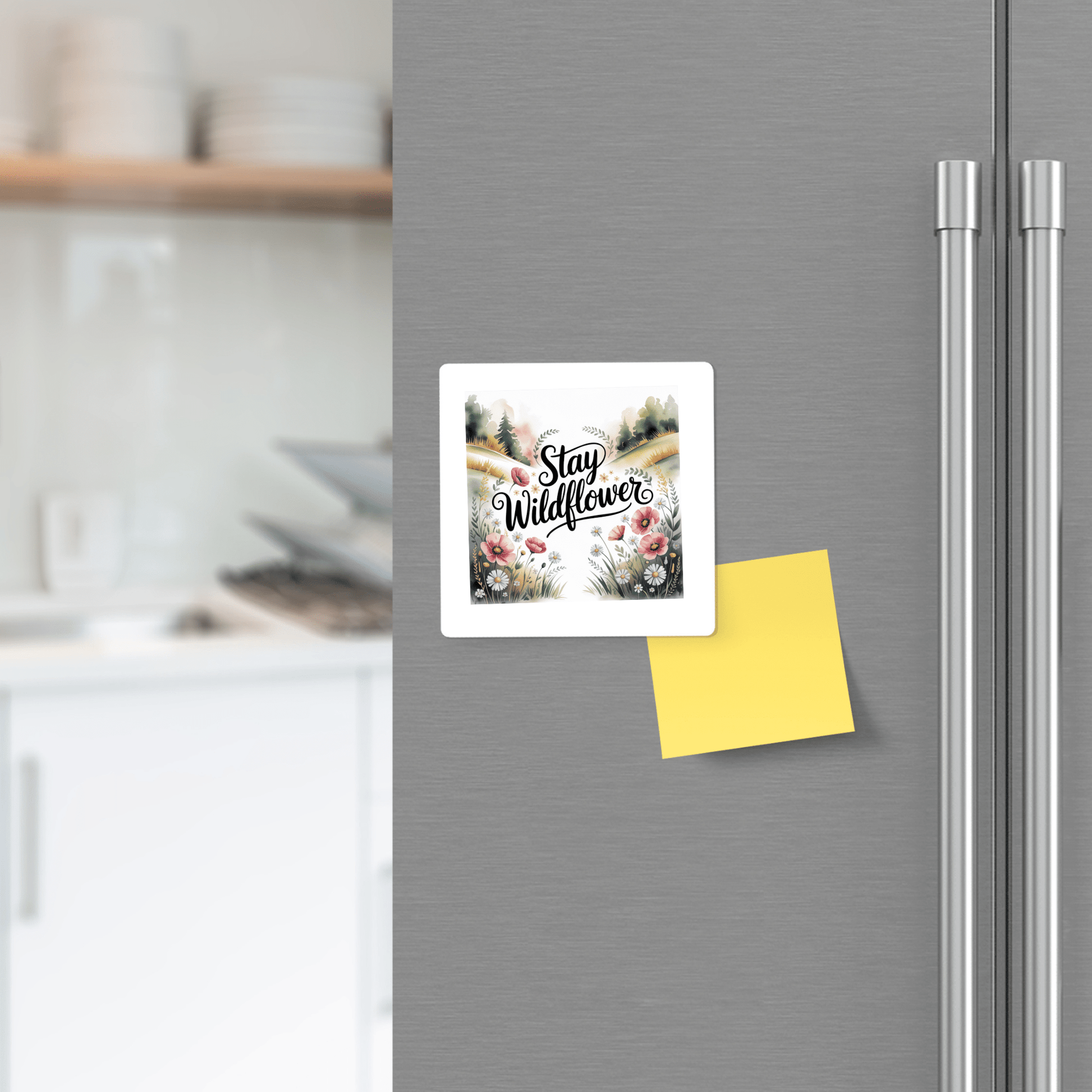 A Mirabilia Boutique "Stay Wildflower" floral quote magnet accents the refrigerator, paired with a yellow sticky note and meadowcore decor, set against a softly blurred kitchen background.