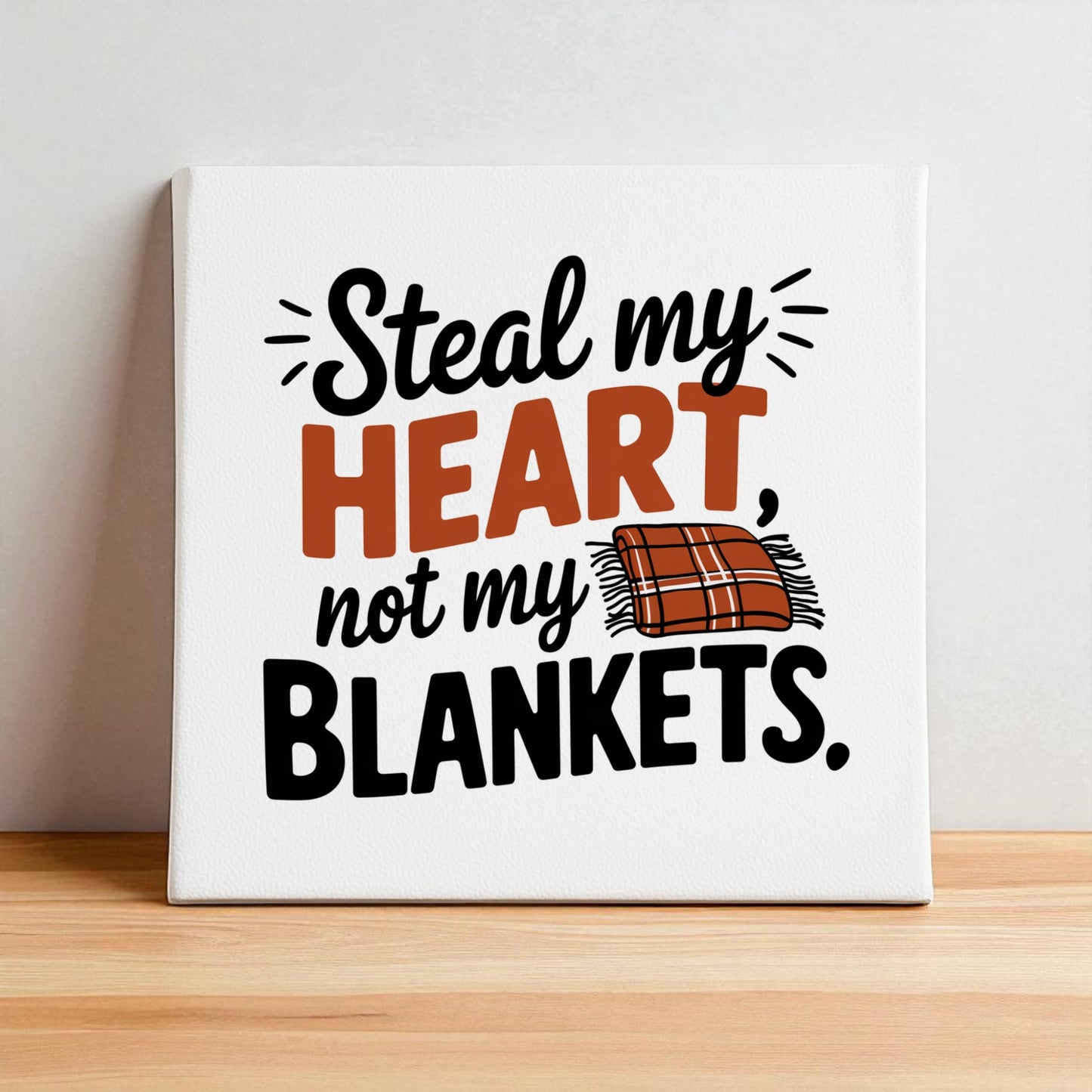 Mirabilia Boutique’s “Steal My Heart Not My Blankets” 8x8 canvas sign features bold orange text, playful black lettering, and a plaid blanket illustration—perfect bedroom décor or a fun couples’ gift.