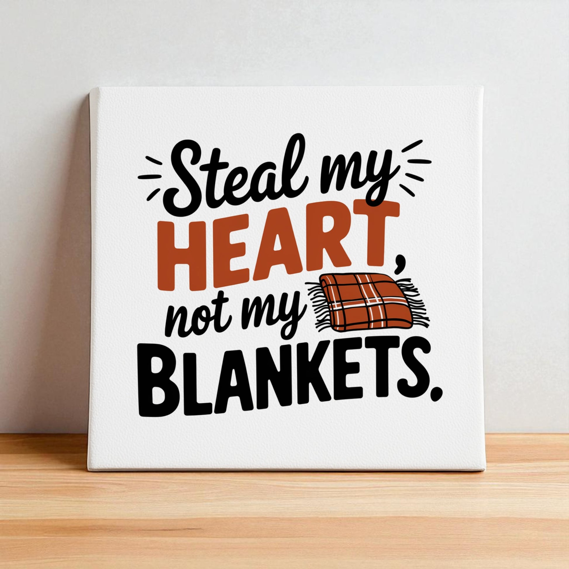 Mirabilia Boutique’s “Steal My Heart Not My Blankets” 8x8 canvas sign features bold orange text, playful black lettering, and a plaid blanket illustration—perfect bedroom décor or a fun couples’ gift.
