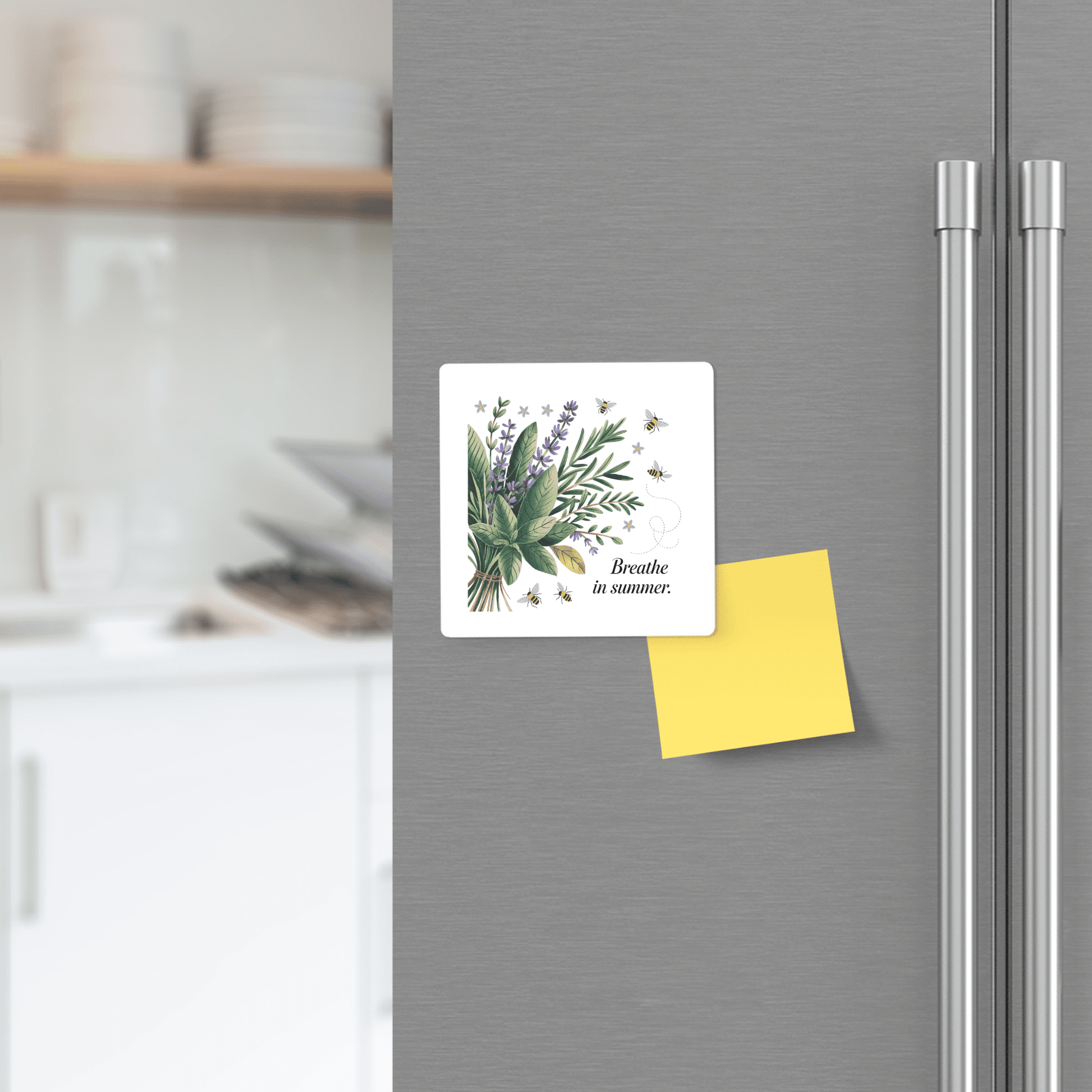A refrigerator door displays the Mirabilia Boutique "Breathe in Summer" botanical magnet with calm bees and a yellow sticky note. Blurred kitchen shelves with dishes are visible in the background.