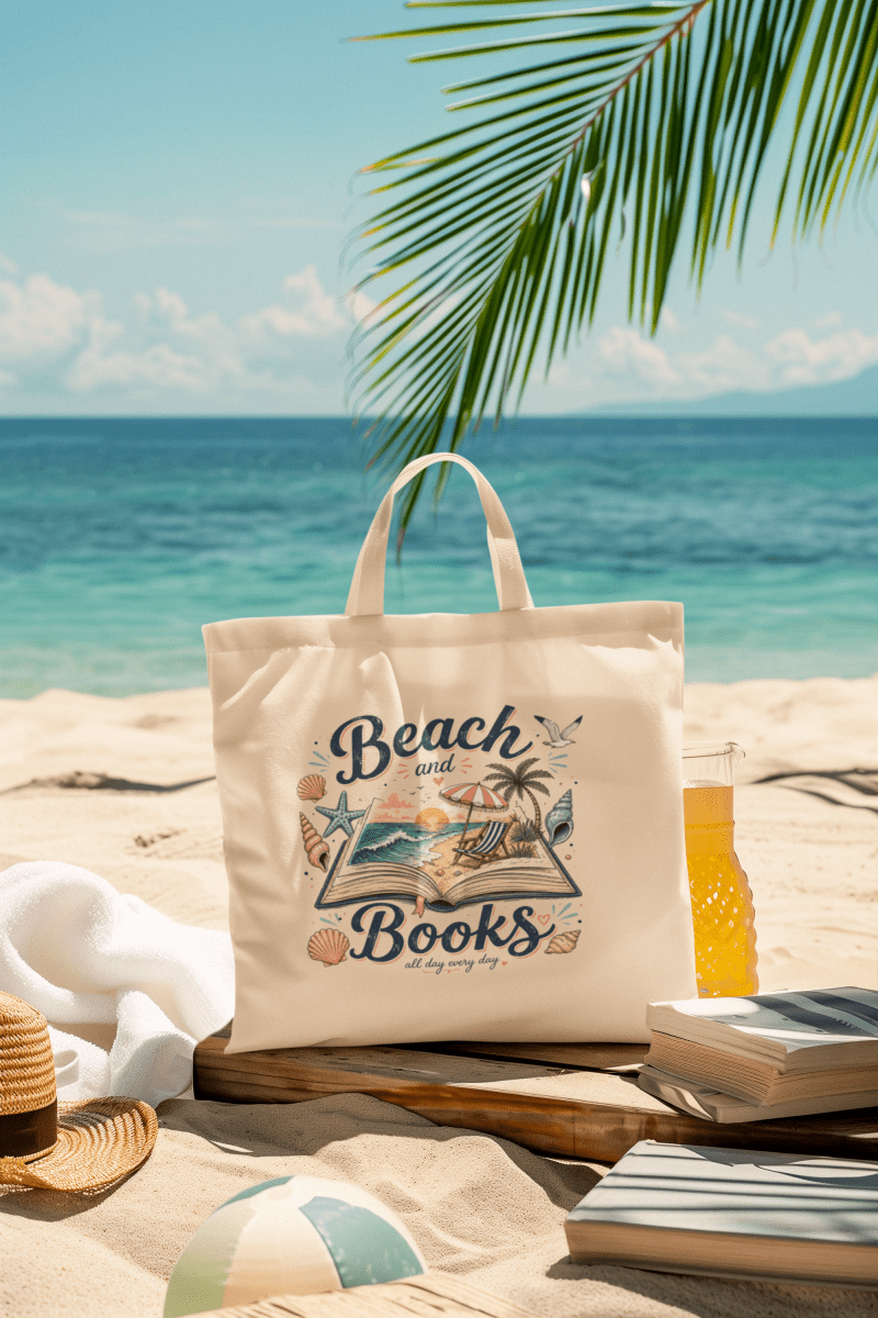 The Mirabilia Boutique Beach and Books Canvas Tote Bag rests on the sand with books, a drink, towel, and hat—an ideal gift for book lovers. Palm leaves, a beach ball, and the ocean glisten in the sunny background.