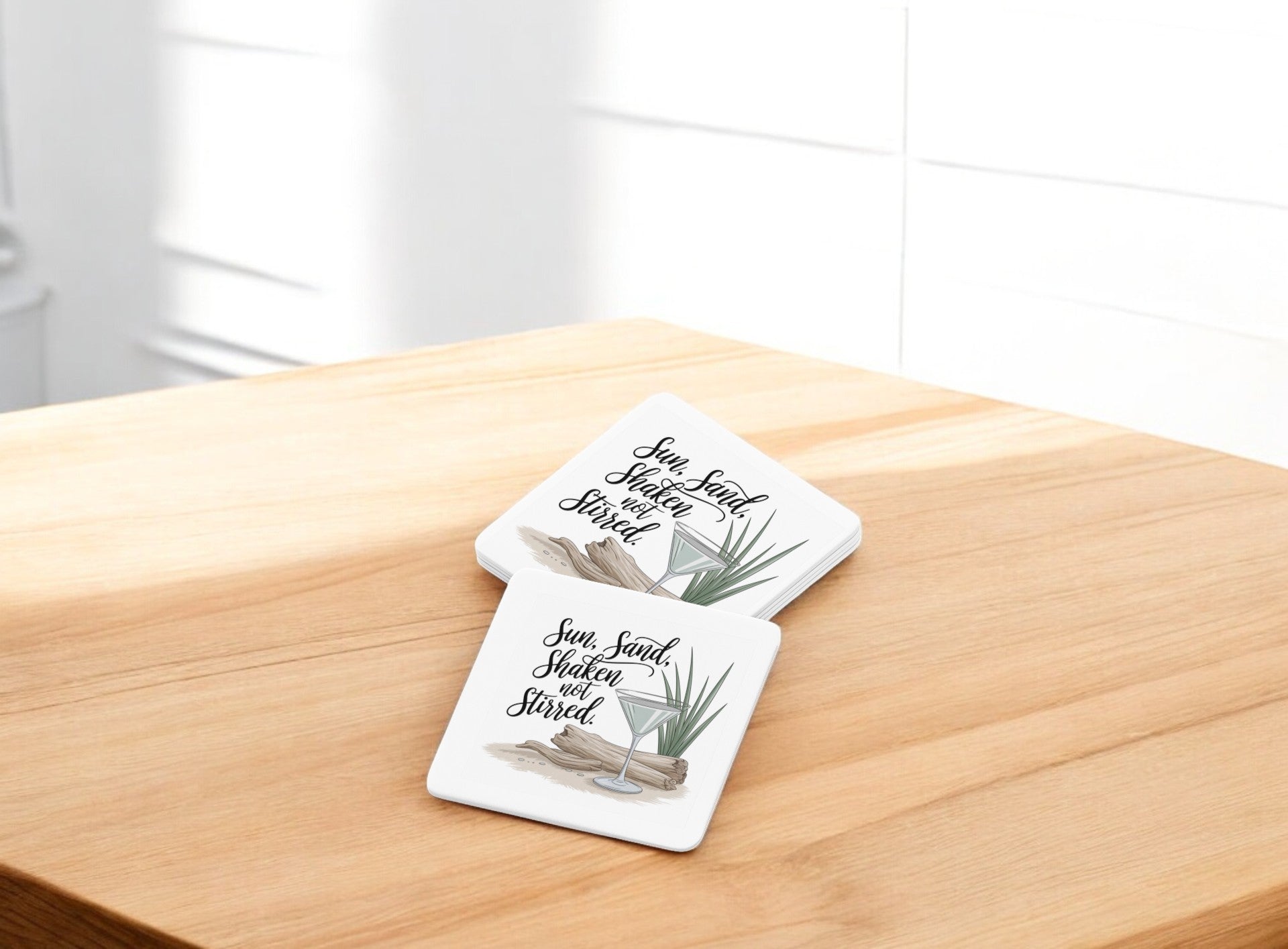 The Sun, Sand, Shaken Not Stirred Coaster Set by Mirabilia Boutique features two square coasters with a coastal summer vibe, perfect for bright spaces or your bar cart.