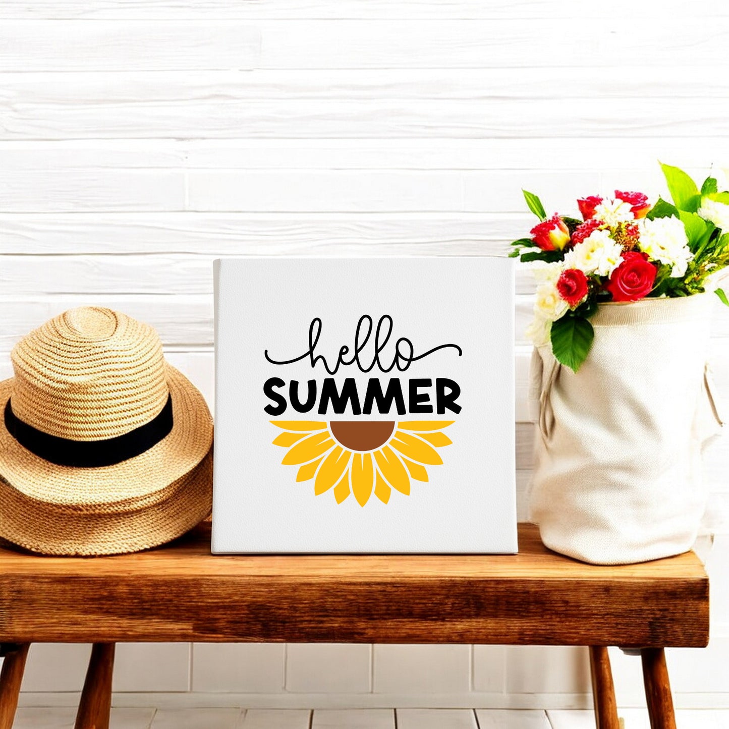 A straw hat, a floral tote bag, and the Mirabilia Boutique Hello Summer Sunflower Canvas Sign (8x8 wall art) are displayed on a wooden bench against a white tiled wall.