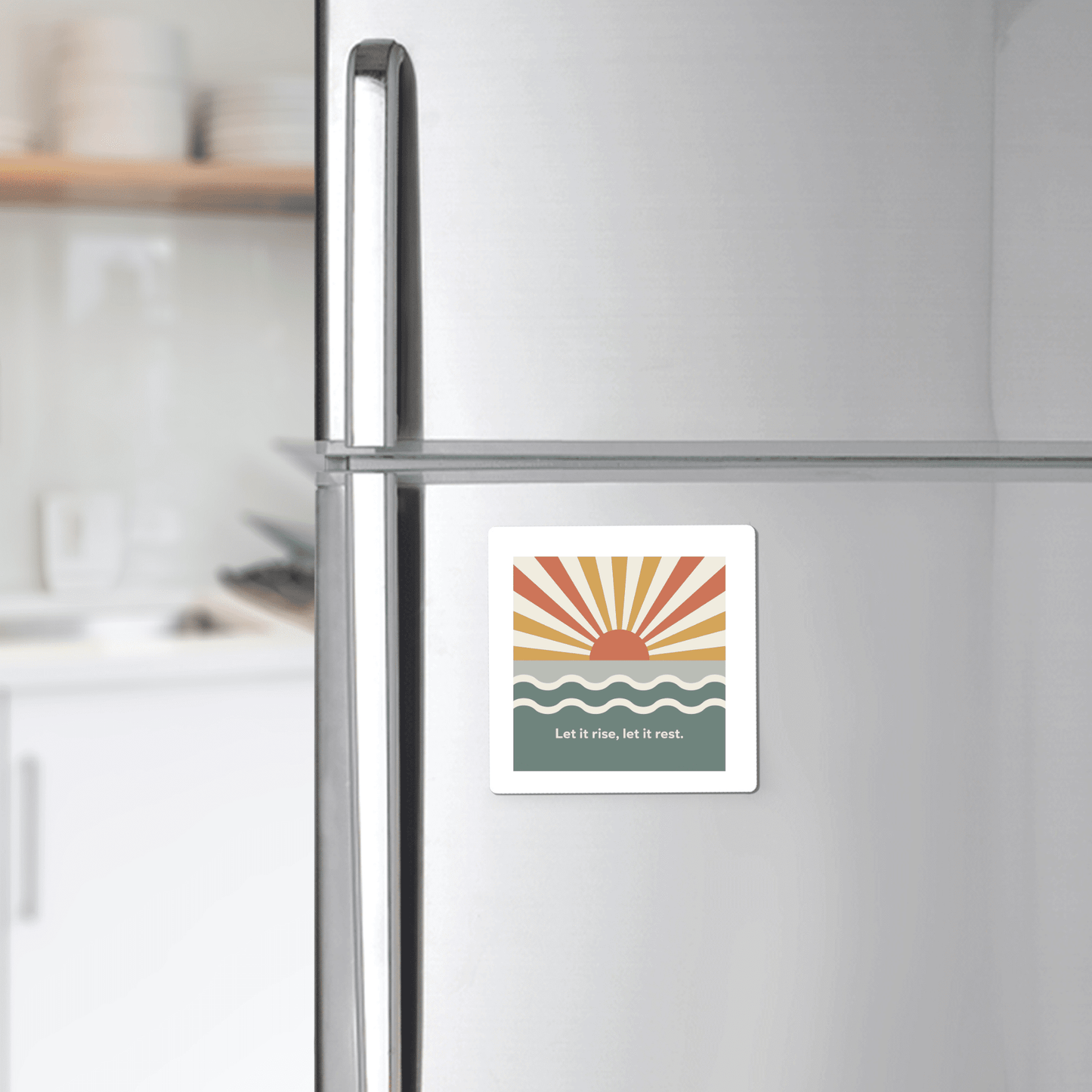 The Let It Rise, Let It Rest Magnet – Sunrise Affirmation by Mirabilia Boutique features a minimalist sun, rays, and waves design with uplifting text—perfect for inspiring your kitchen décor.