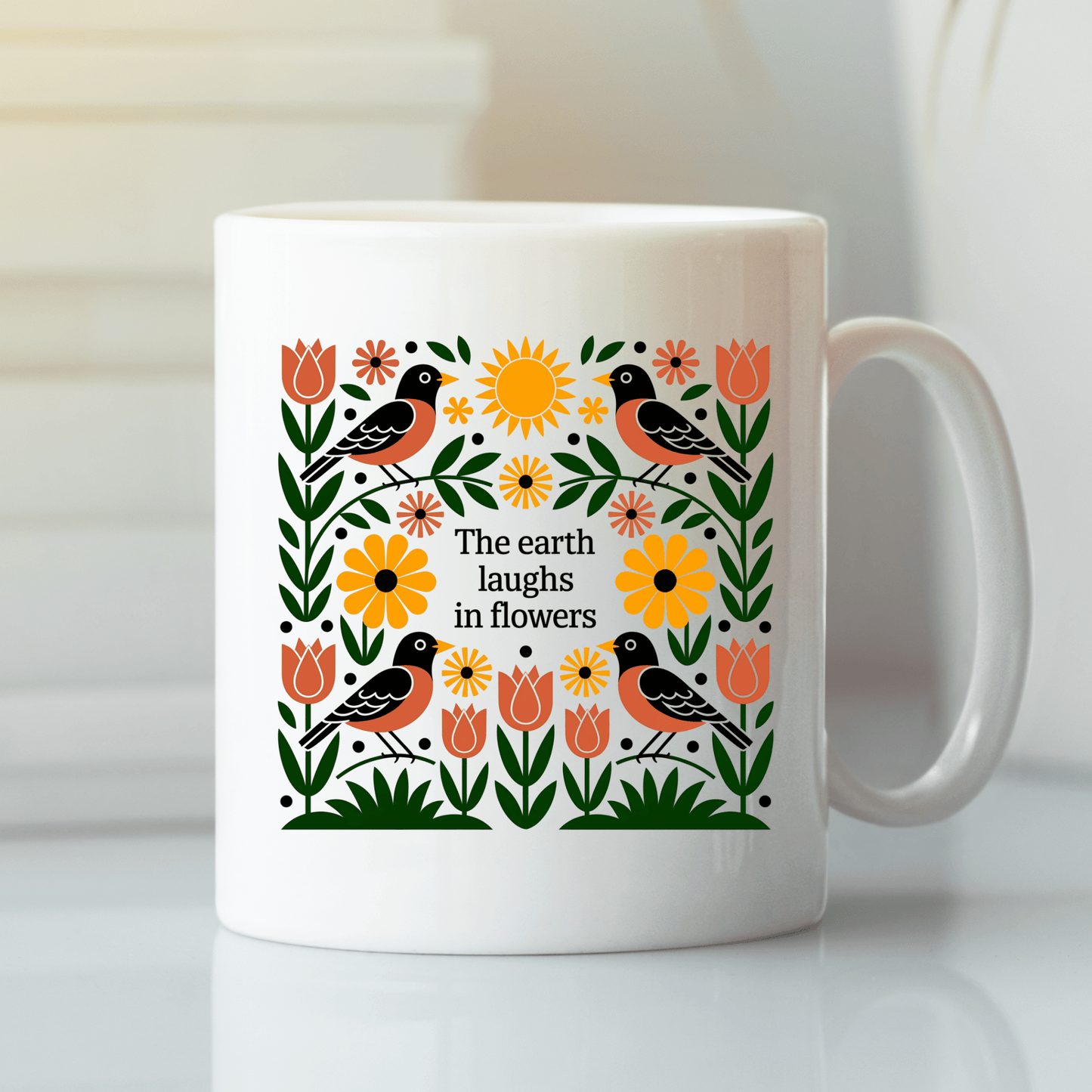 The Earth Laughs in Flowers Spring Mug by Mirabilia Boutique is a white ceramic mug featuring a vibrant folk-art design of birds, tulips, and sunflowers, with the quote "The earth laughs in flowers"—a perfect floral gift for nature lovers.