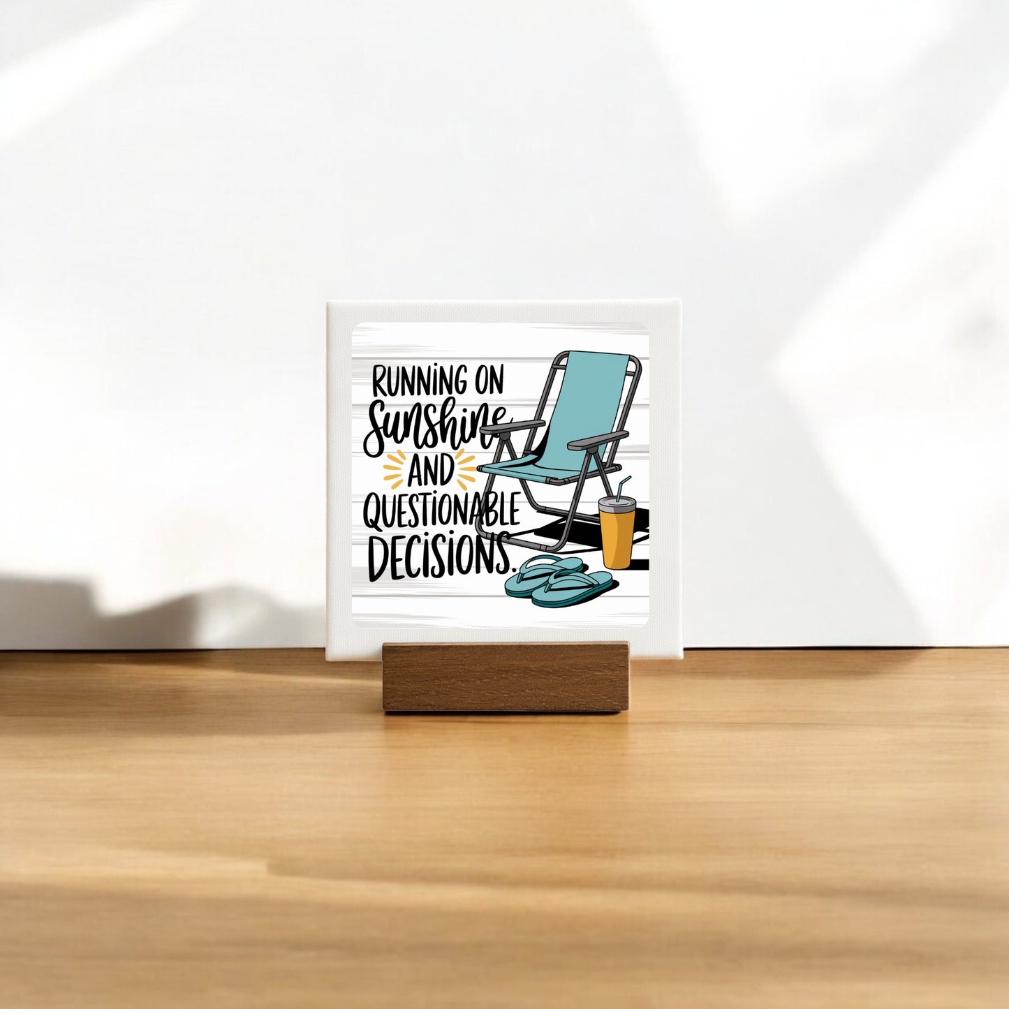 The Running on Sunshine Mini Canvas (4x4) by Mirabilia Boutique features a lounge chair, sunglasses, and drink with the phrase "Running on sunshine and questionable decisions." A fun summer sign perfect for poolside decor.