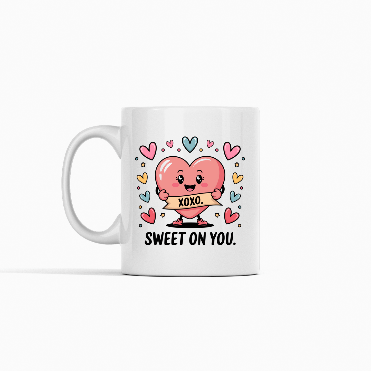 The Sweet On You Heart Mug by Mirabilia Boutique features a cute pink heart holding an "XOXO" sign, colorful hearts, and "SWEET ON YOU." text—an adorable Valentine's gift for someone special.