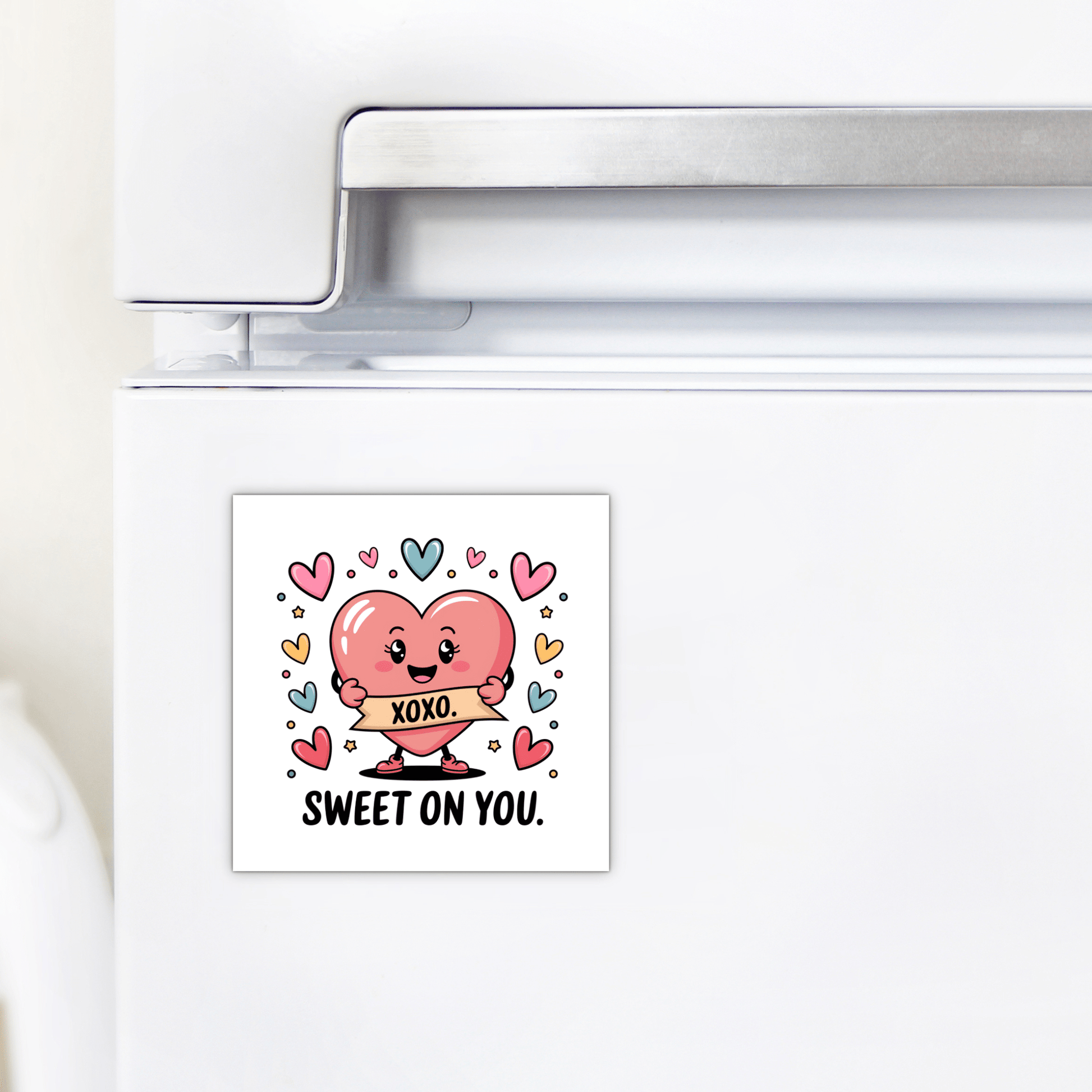 The Sweet on You Valentine Magnet by Mirabilia Boutique is a square fridge magnet with a smiling cartoon heart holding an "XOXO" banner, colorful hearts, and "SWEET ON YOU." text—ideal for romantic kitchen decor or as a love note.