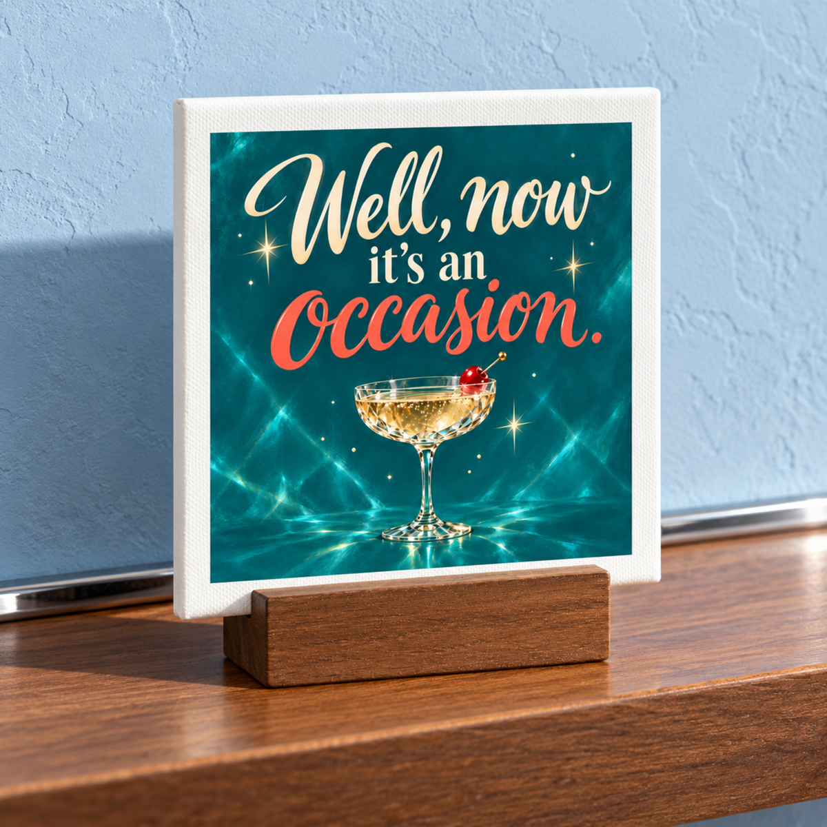 A square Well, Now It’s an Occasion Mini Bar Sign on a wooden stand featuring a cocktail glass with a cherry and the text, “Well, now it’s an occasion.”.