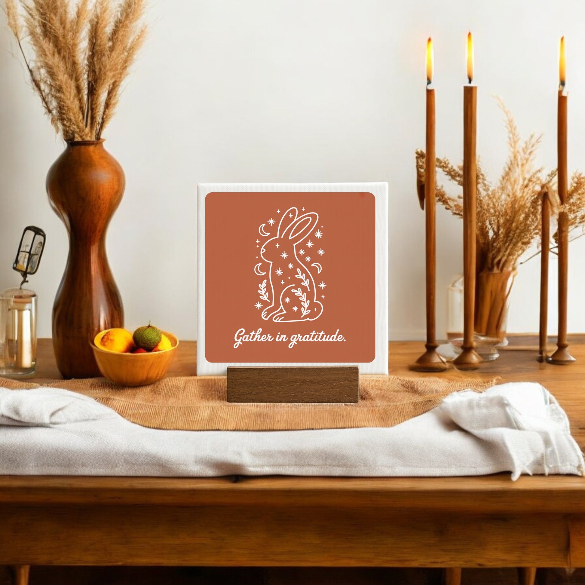 The Mirabilia Boutique Gather in Gratitude Mini Canvas Sign – 4x4 Bunny features a charming white rabbit and inspiring words, making it perfect for cozy, autumn-themed home decor on tables or shelves.