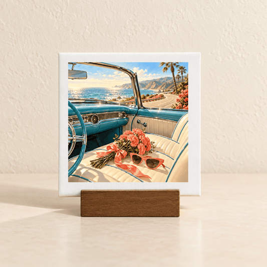 The Best Is Still Ahead Birthday Mini Sign, a square tabletop artwork in a wooden stand showing the interior of a vintage blue convertible parked by the ocean with a bouquet of pink flowers and sunglasses on the seat.