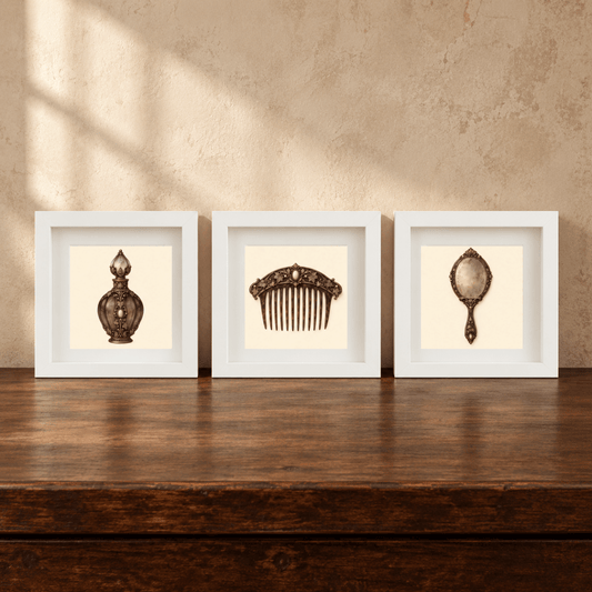 Three white-framed shadow box frames from Mirabilia Boutique’s “The Last Dressing Table | Mirabilia Relics” display a perfume bottle, an ornate hair comb, and a vintage handheld mirror on a wooden table against a beige textured wall—a sophisticated art set that brings timeless charm and elegance to your space.