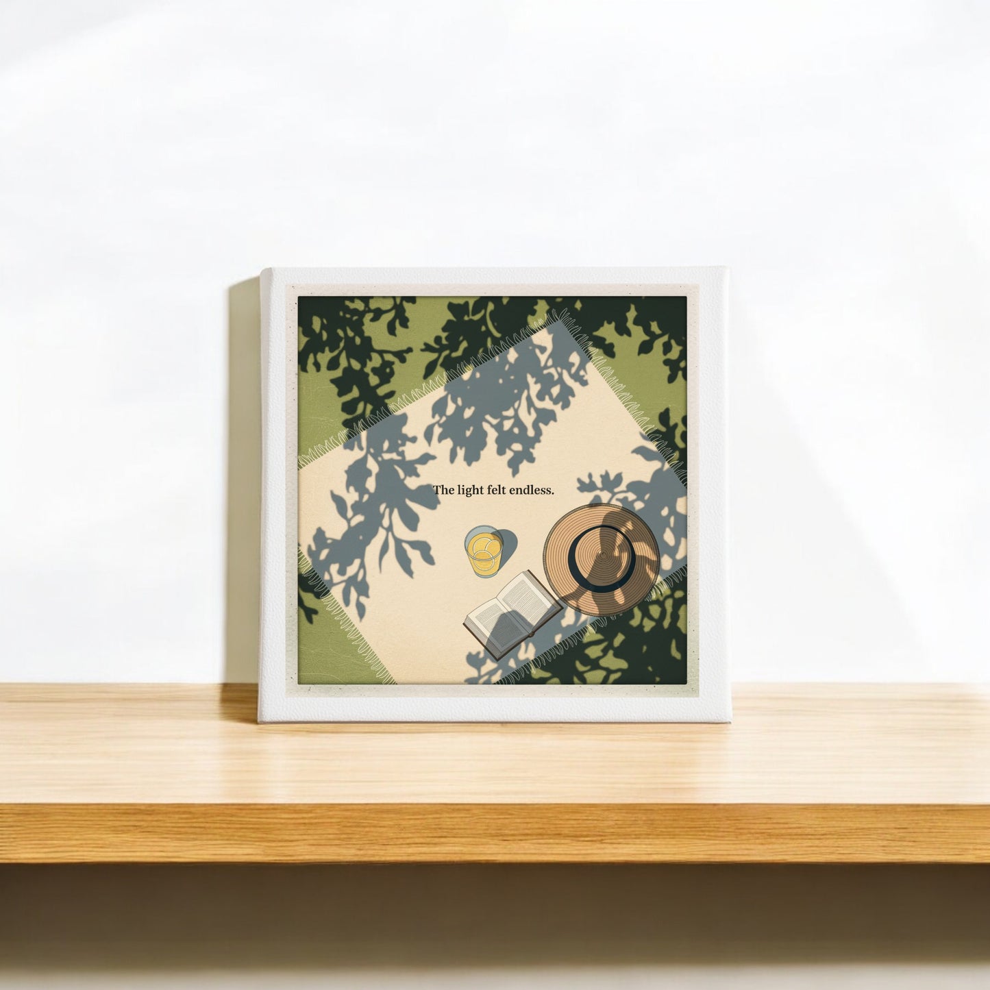 The Light Felt Endless Canvas – Summer Stillness Art by Mirabilia Boutique features shadows of leaves over a book, cup, and bulb with the phrase "The light felt endless."—ideal gallery wall art for lovers of slow living and gentle light.