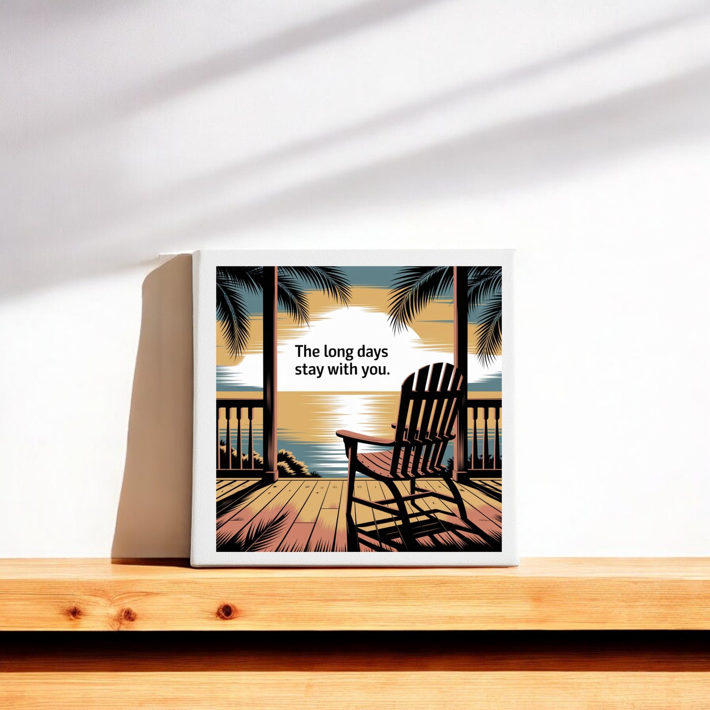 The Long Days Canvas – Sunset Memory Porch Art by Mirabilia Boutique features a gallery-wrapped print of a deck, chair, palm trees, and sunset with the words "The long days stay with you." Perfect ocean horizon decor for any room.