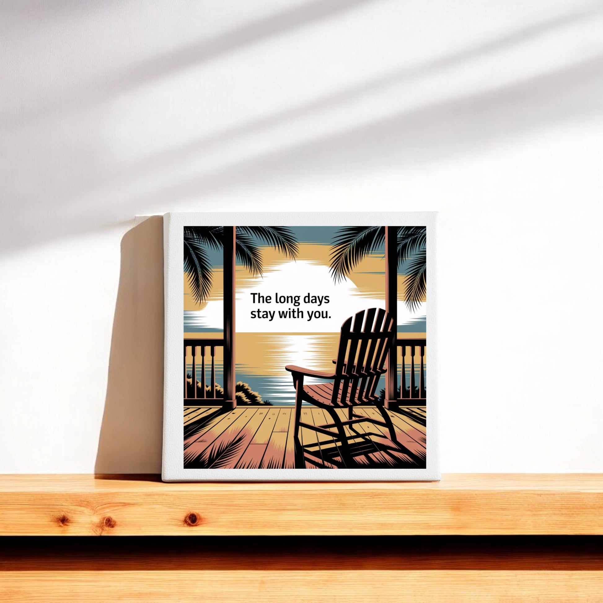 The Long Days Canvas – Sunset Memory Porch Art by Mirabilia Boutique features a gallery-wrapped print of a deck, chair, palm trees, and sunset with the words "The long days stay with you." Perfect ocean horizon decor for any room.