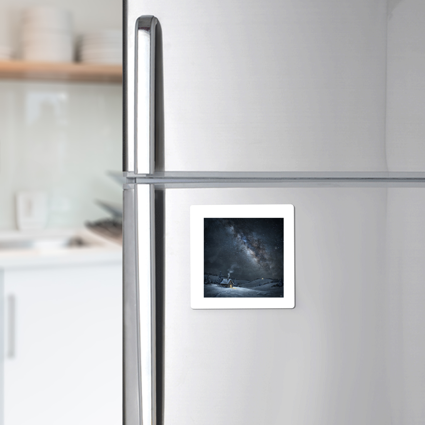 A “The Night Is Listening Milky Way Magnet” from Mirabilia Boutique, showcasing celestial art, is attached to a silver refrigerator in a modern kitchen.