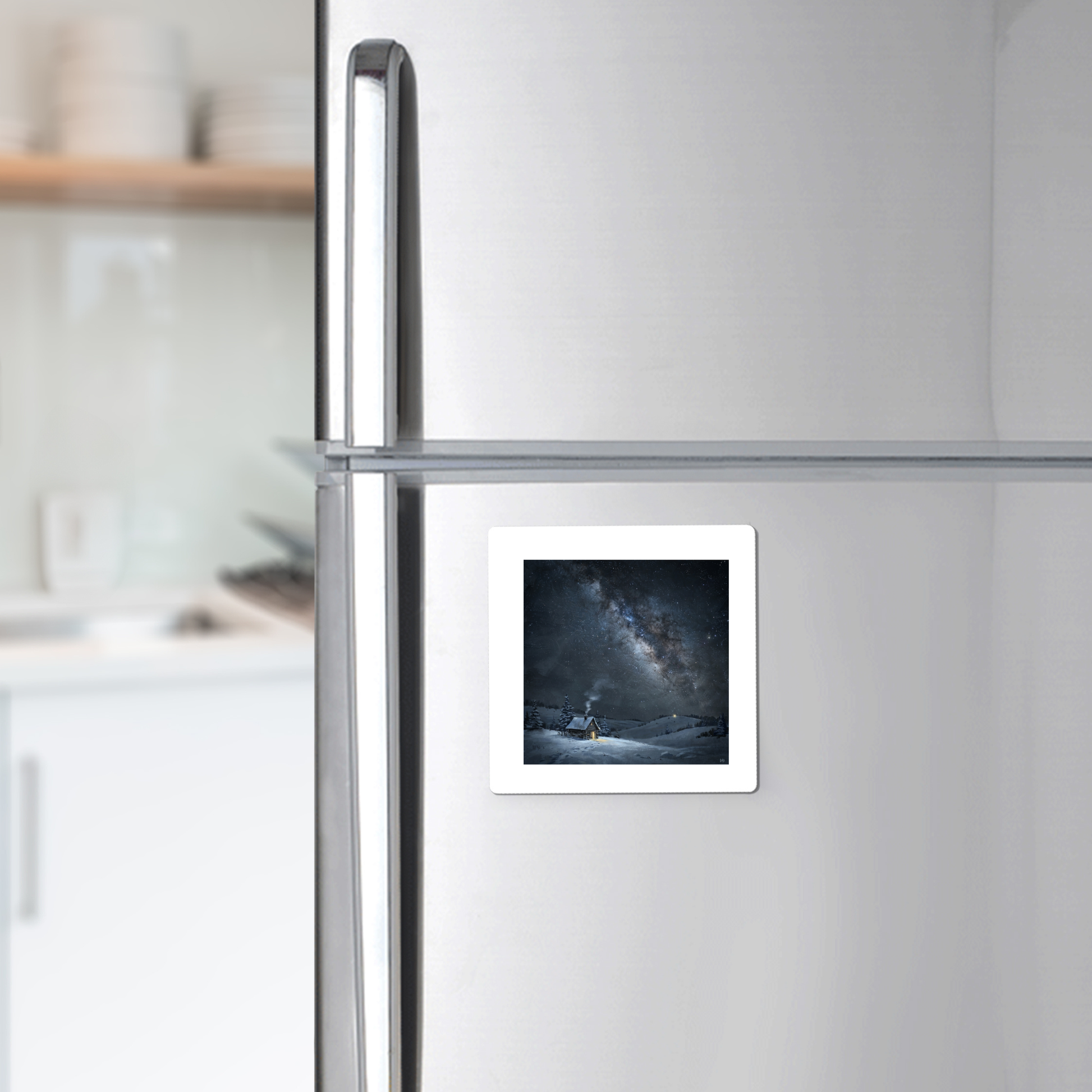 A “The Night Is Listening Milky Way Magnet” from Mirabilia Boutique, showcasing celestial art, is attached to a silver refrigerator in a modern kitchen.