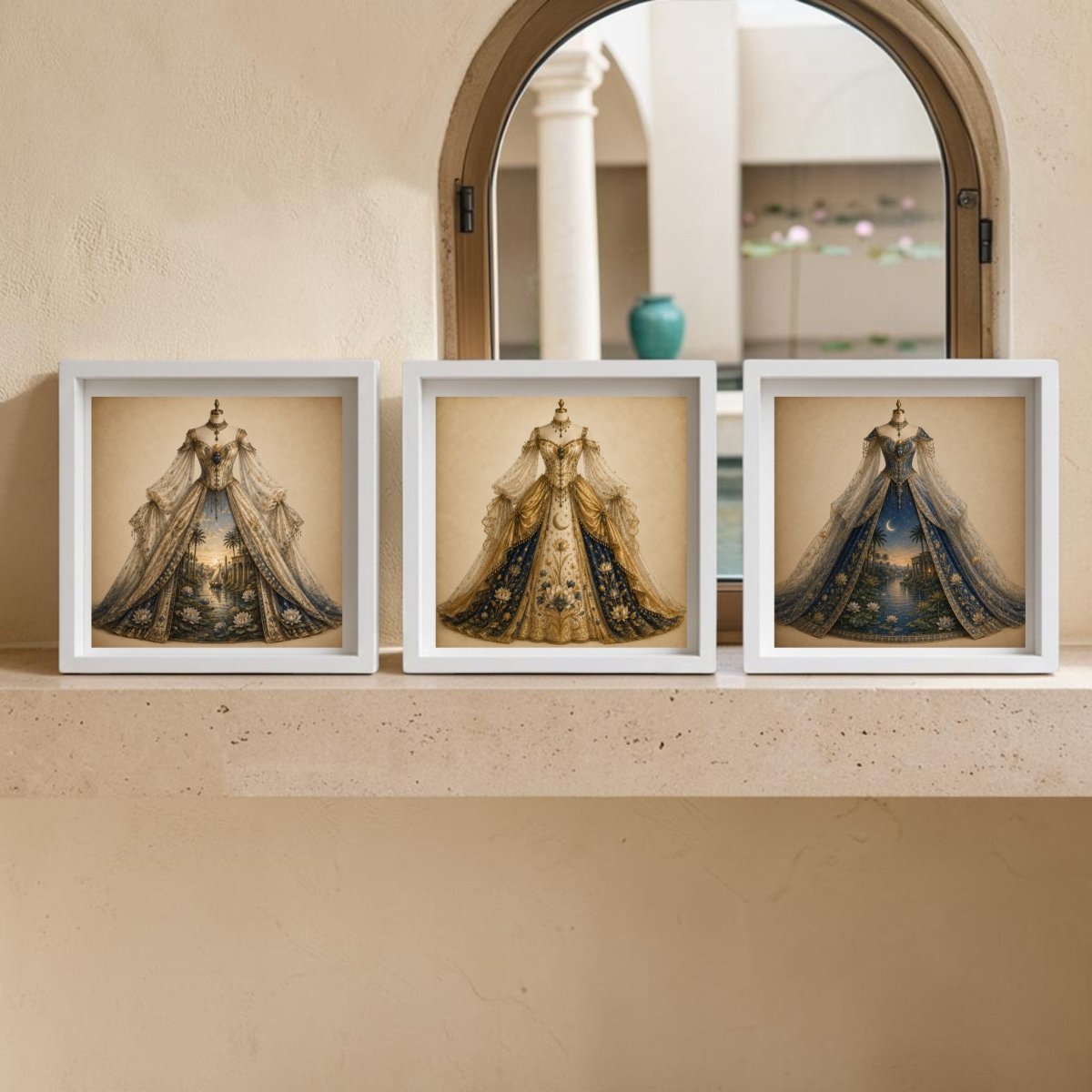 Three framed photos from Mirabilia Boutique’s “The Nile Reverie | Curated Couture Artwork” collection—showcasing ornate, vintage-style gowns reminiscent of couture masterpieces—are displayed on a stone ledge in front of an arched window, with a softly blurred outdoor courtyard visible in the background.