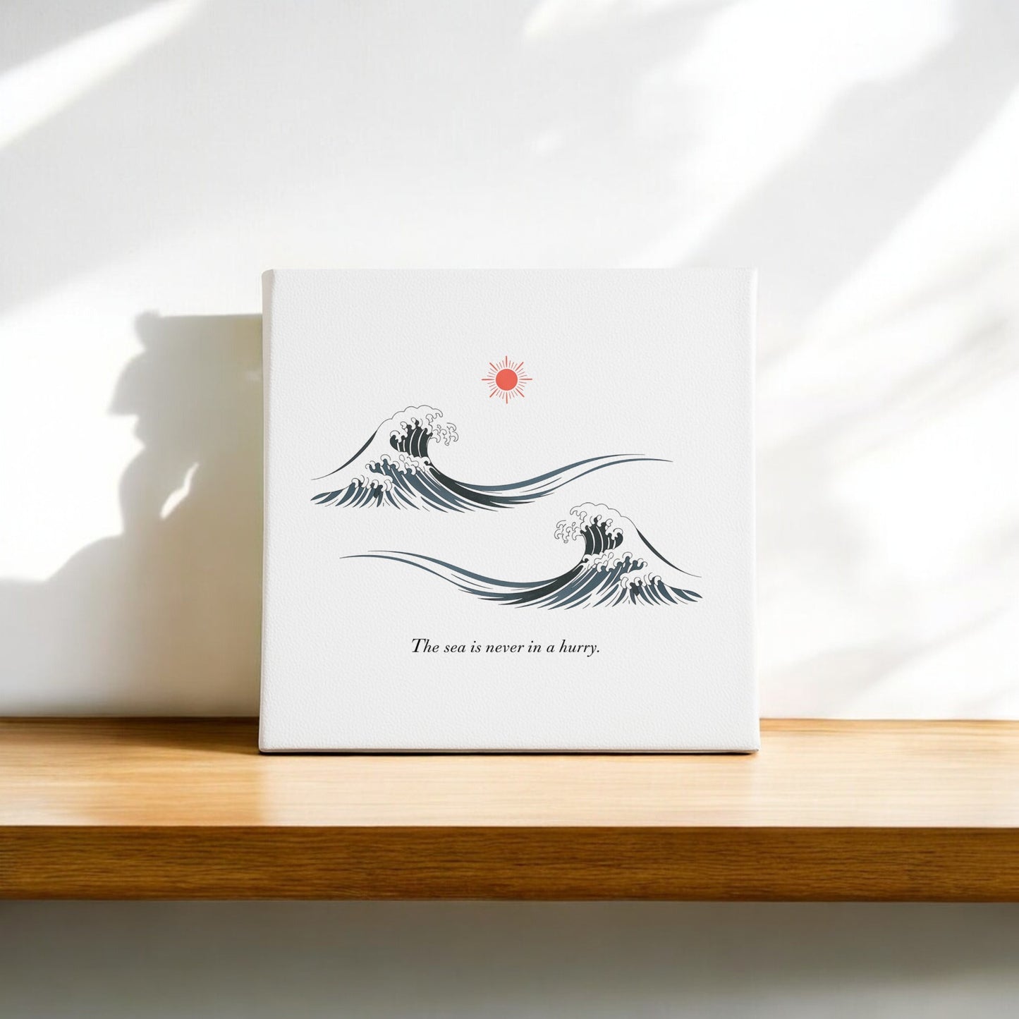 The Sea Is Never in a Hurry Canvas – Serene Ocean Calm by Mirabilia Boutique features stylized ocean waves, a red sun, and the phrase "The sea is never in a hurry," creating serene wall art for a tranquil space.
