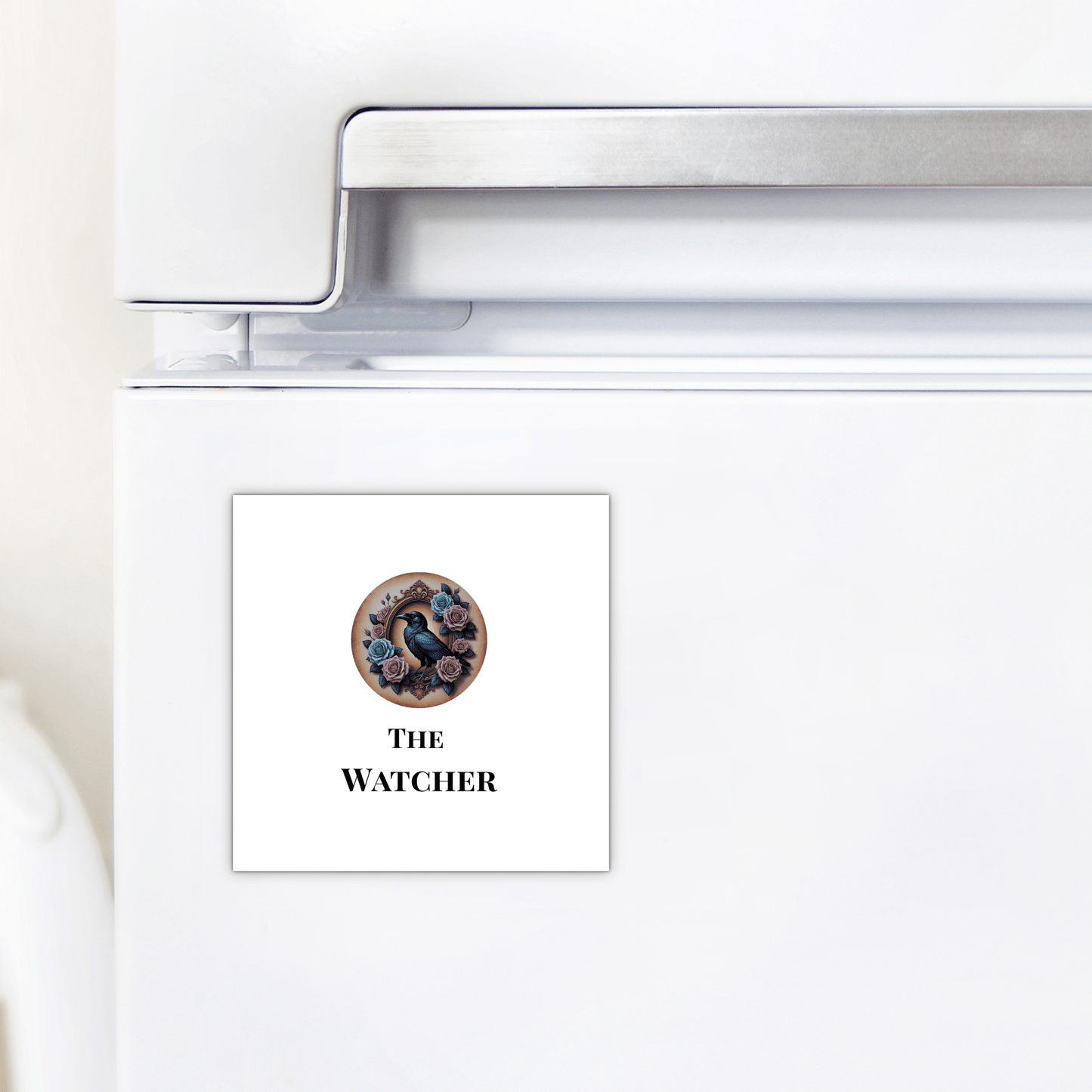 A square "The Watcher Magnet" by Mirabilia Boutique features a black bird and flowers above “THE WATCHER”—a gothic fridge accessory and perfect dark academia gift for home decor fans.