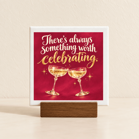 A square There’s Always Something Worth Celebrating Mini Bar Sign on a wooden stand, featuring the text “There’s always something worth celebrating” above two clinking champagne glasses on a red background.