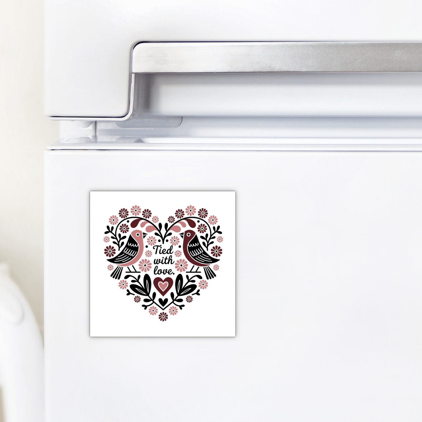 The Tied With Love Birds Magnet by Mirabilia Boutique features two black birds with floral accents in a heart shape and the words "Tied with love," making it a charming wedding favor for display on any white refrigerator.