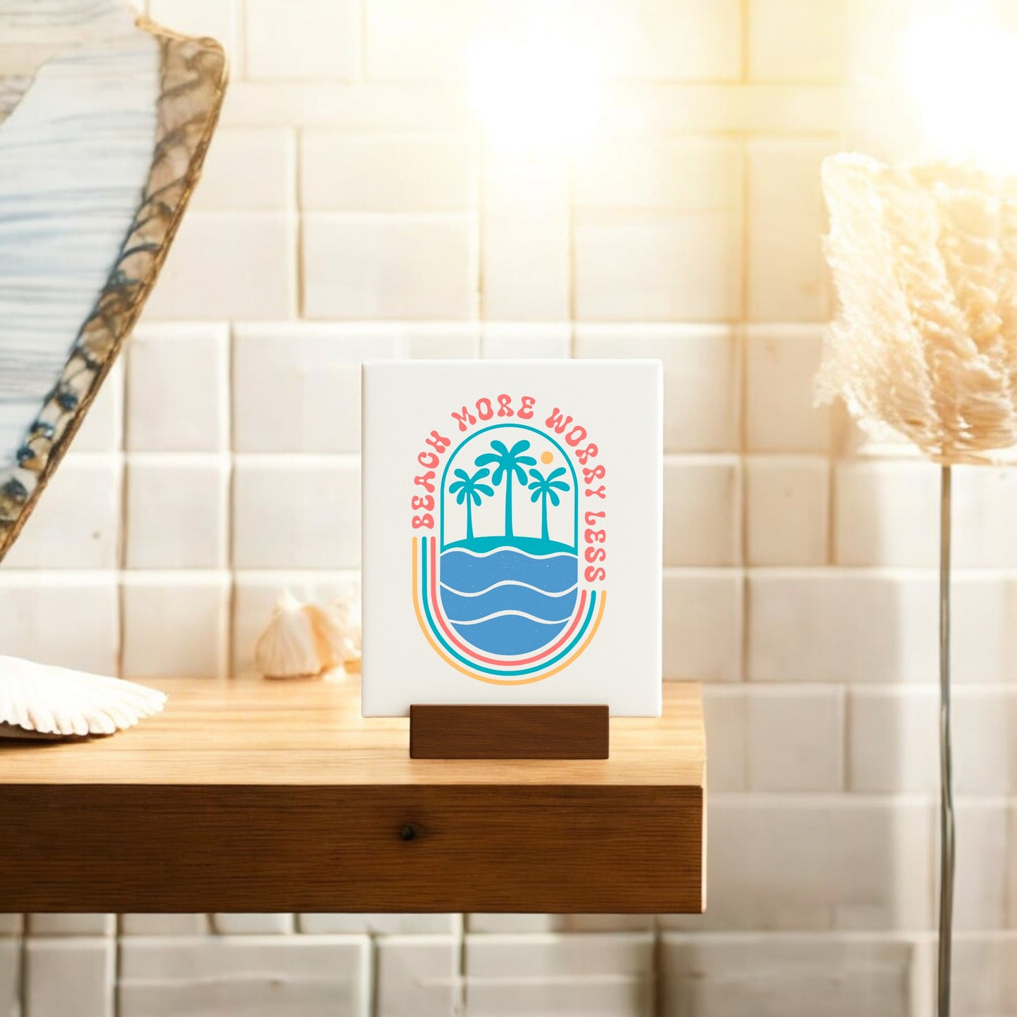 The Beach More Worry Less Retro Summer Sign by Mirabilia Boutique features colorful palm trees and waves, making a charming beach decor piece or summer gift. Display it on a wooden shelf for a relaxed, sunny vibe.