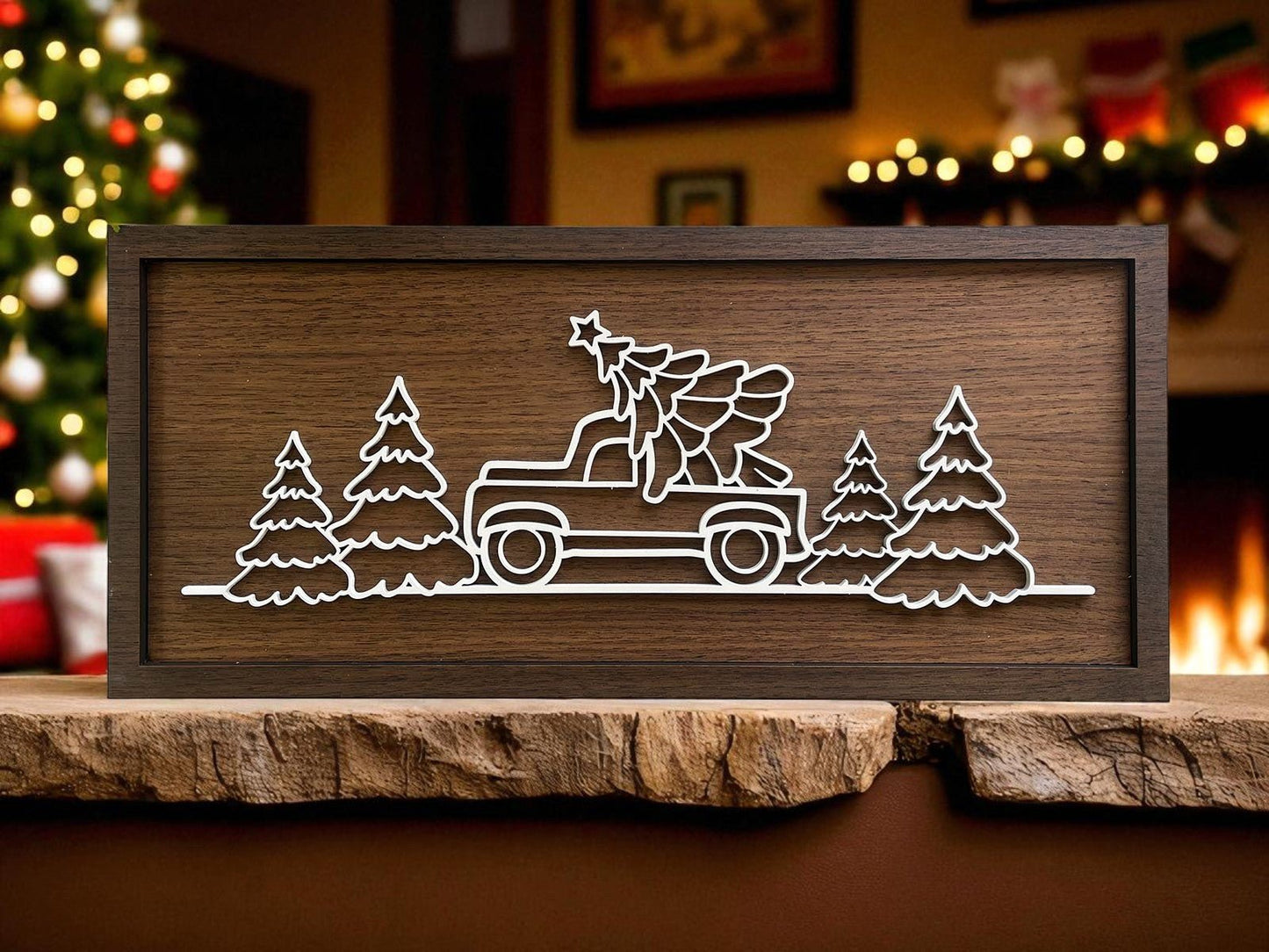 The Truck & Tree Laser Cut Christmas Sign (18x8) by Mirabilia Boutique features a rustic wood design with a white line drawing of a pickup truck carrying a Christmas tree, perfect festive wall art for your holiday-decorated living room.