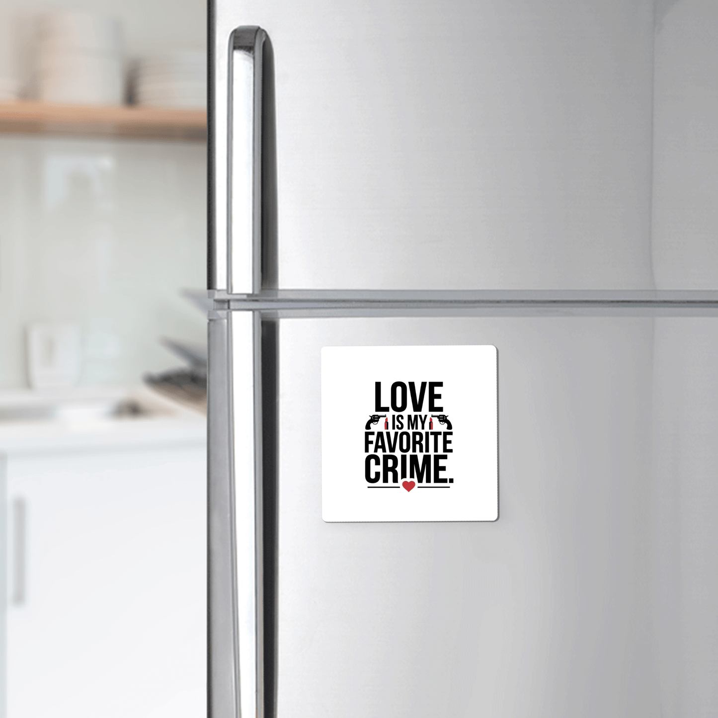 A refrigerator features the "Love Is My Favorite Crime Magnet" by Mirabilia Boutique—bold black letters, red heart—making it a fun, minimalistic kitchen gift for true crime fans.