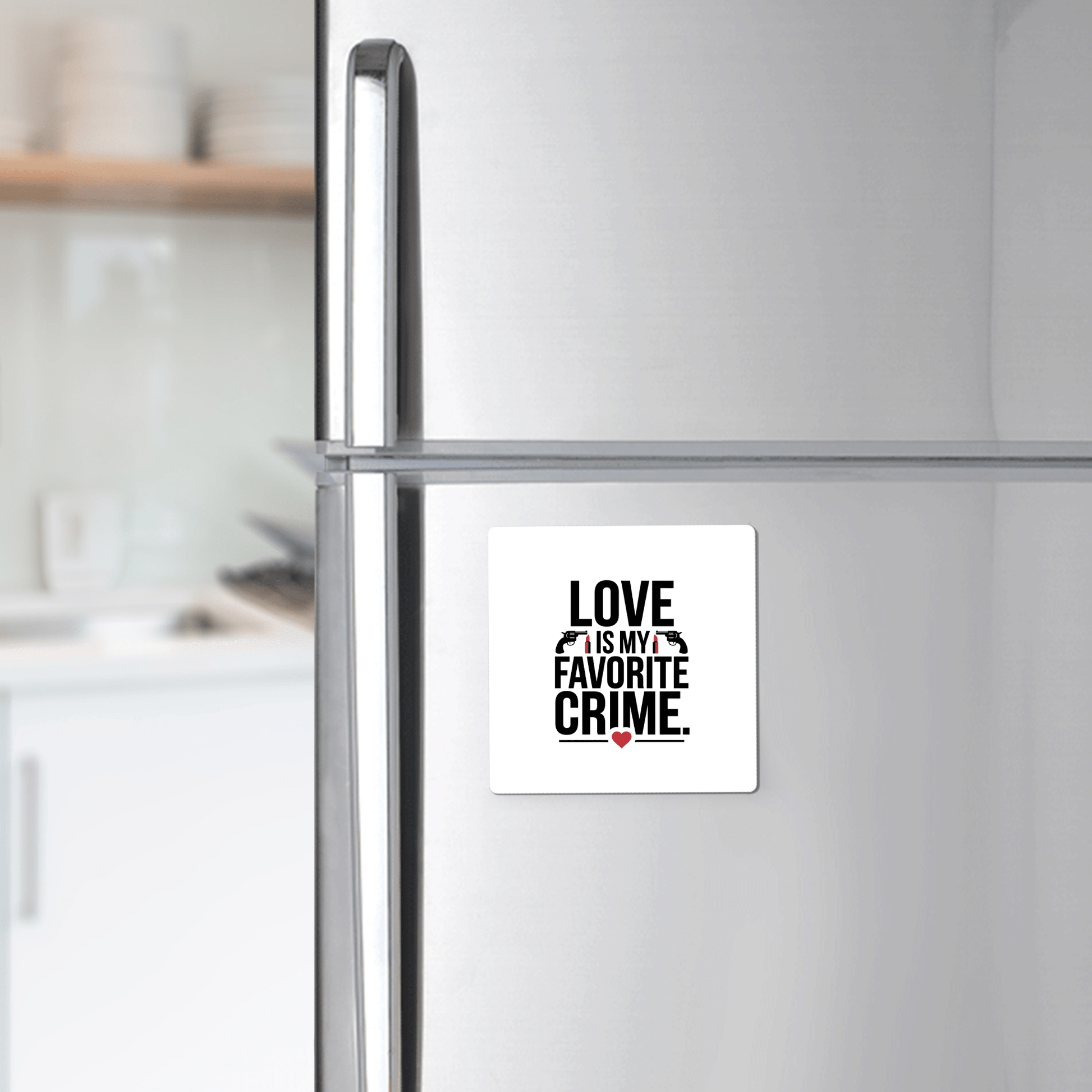 A refrigerator features the "Love Is My Favorite Crime Magnet" by Mirabilia Boutique—bold black letters, red heart—making it a fun, minimalistic kitchen gift for true crime fans.