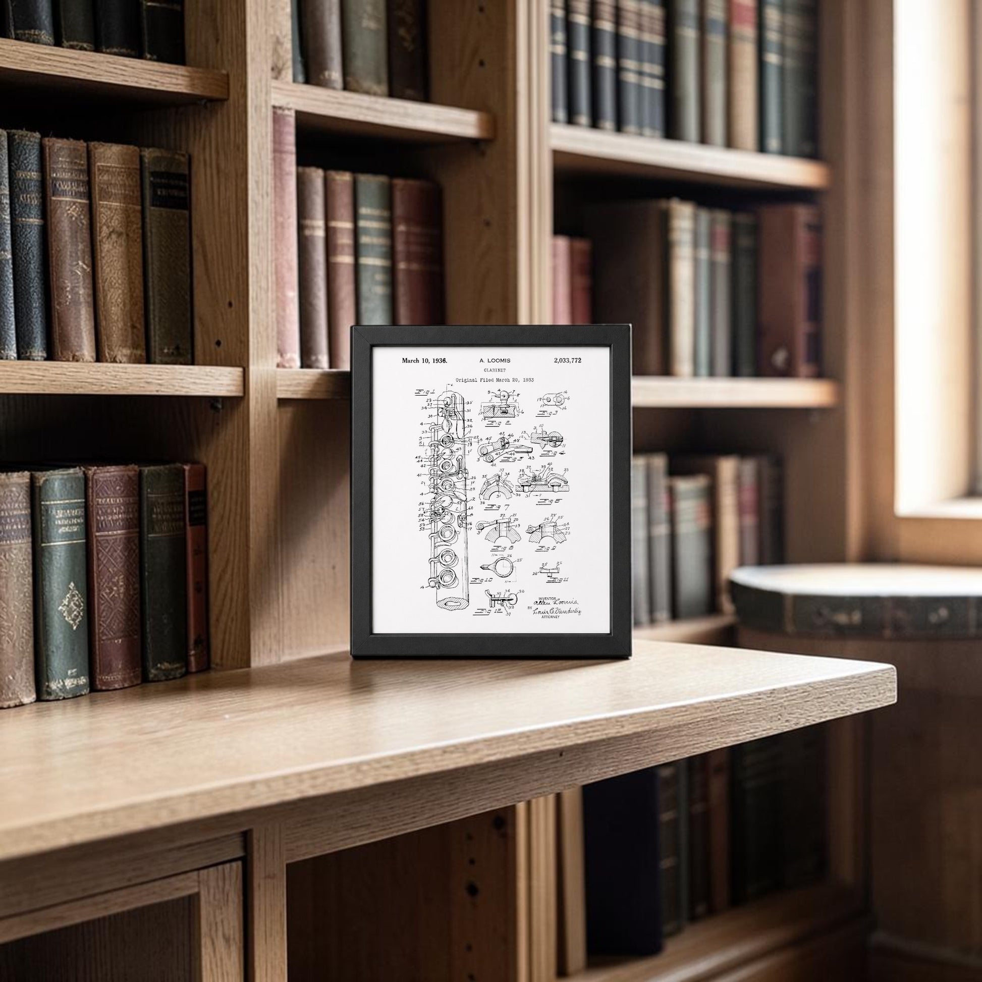 An e-reader with handwritten notes sits on a wooden desk in a library filled with books, while the Clarinet Patent Print on Metal Wall Art by Mirabilia Boutique brings a modern flair to the scholarly, naturally lit setting.