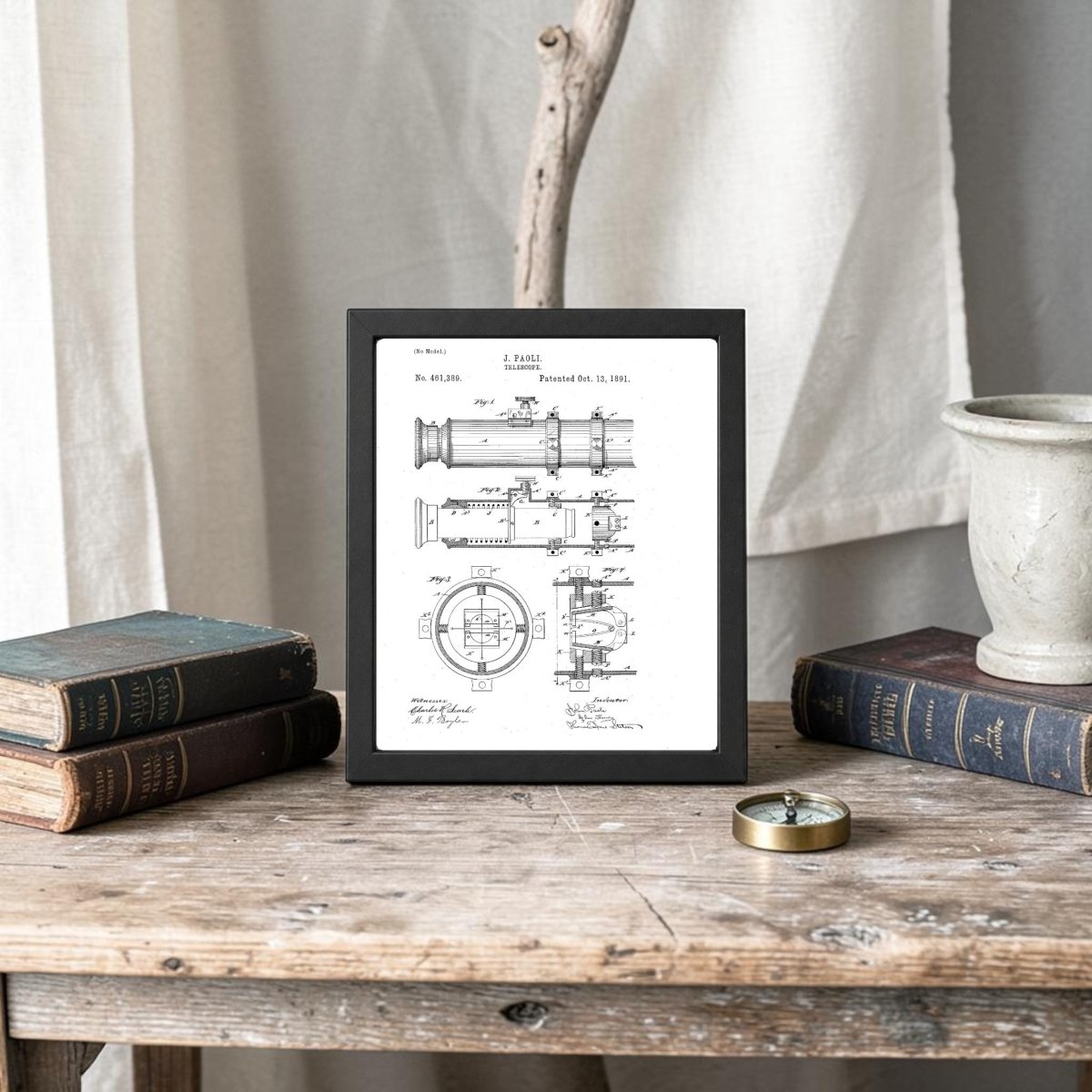 The Nautical Telescope Patent Art Print by Mirabilia Boutique is displayed framed on a rustic wooden table with vintage books, a compass, a stone vase, and a branch. Neutral-toned curtains provide an elegant backdrop.