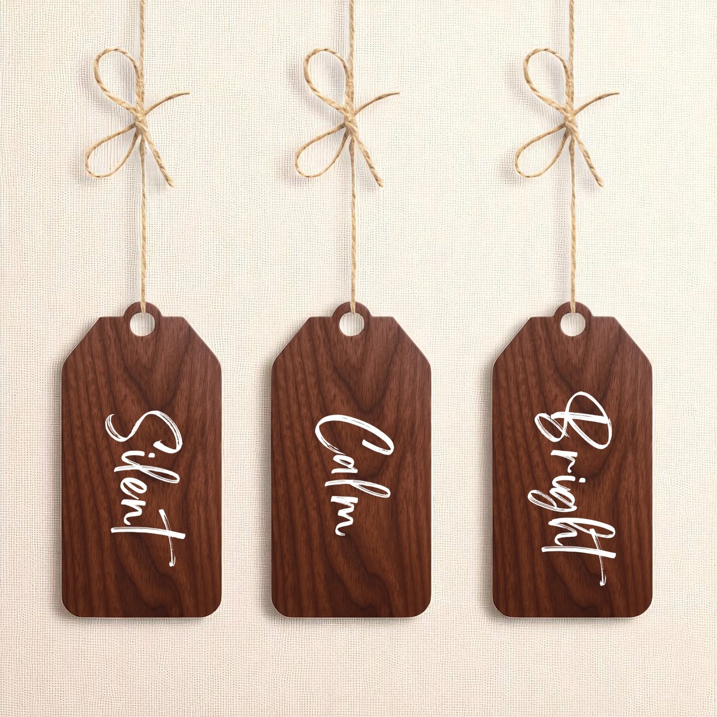 The Mirabilia Boutique Walnut Holiday Tags Set includes three minimalist walnut Christmas ornaments labeled “Silent,” “Calm,” and “Bright” for a charming holiday touch.