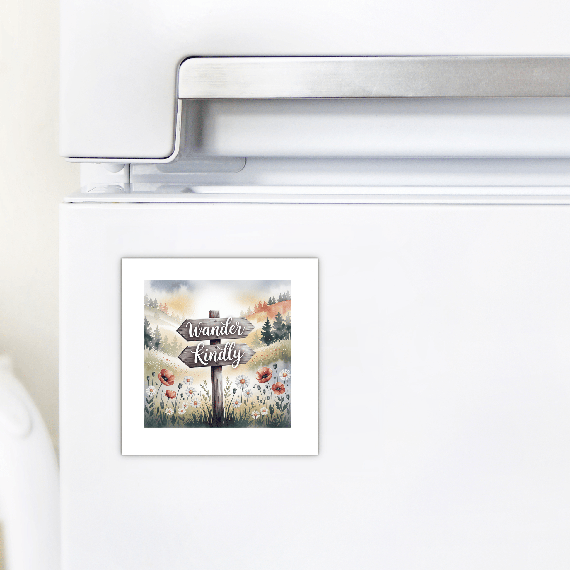 The Mirabilia Boutique Wander Kindly Magnet features a scenic mountain, tree, and wildflower illustration with an inspirational quote—ideal for adding nature-inspired decor to your white refrigerator.