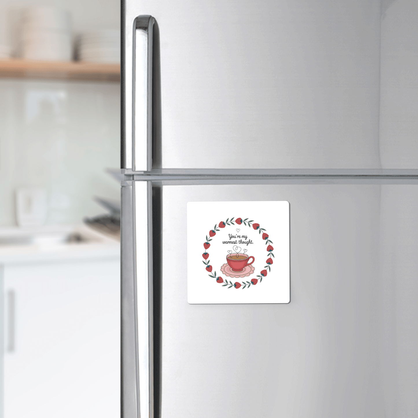 The Warmest Thought Tea Cup Magnet by Mirabilia Boutique, featuring a red teacup and wreath with “You are my cup of tea,” adorns your fridge—a charming best friend gift and stylish touch for any modern kitchen.