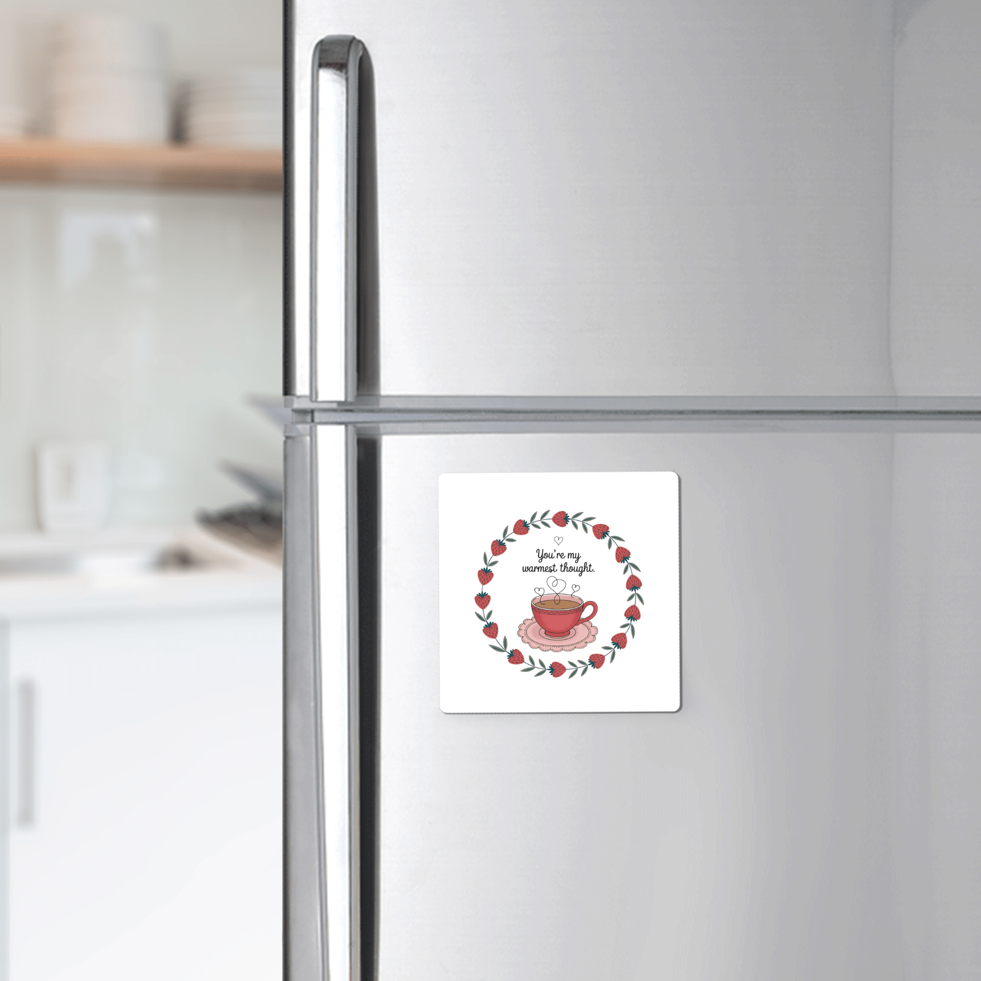 The Warmest Thought Tea Cup Magnet by Mirabilia Boutique, featuring a red teacup and wreath with “You are my cup of tea,” adorns your fridge—a charming best friend gift and stylish touch for any modern kitchen.