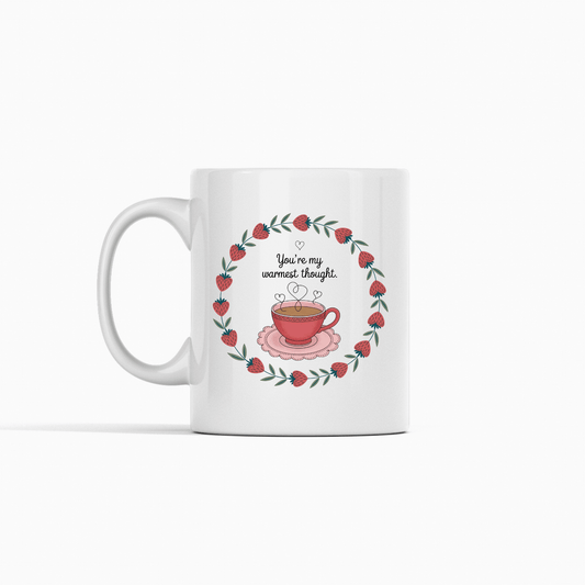 The Warmest Thought Mug – Sweet Teacup Gift Mug by Mirabilia Boutique is a white ceramic mug with a rose-hued teacup, heart-shaped steam, red flowers, and the text "You're my warmest thought" above the cup.
