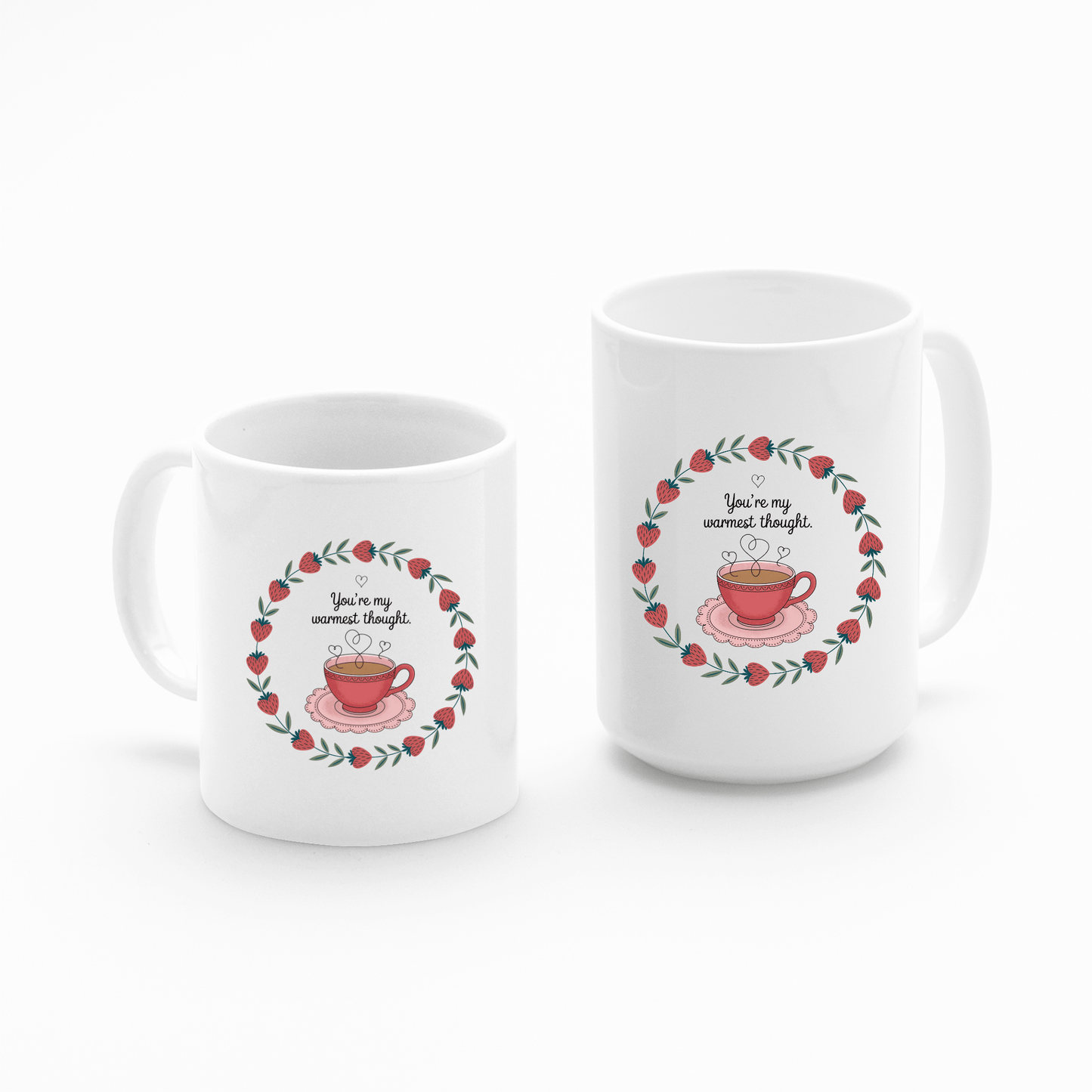 The Warmest Thought Mug set by Mirabilia Boutique includes two white ceramic mugs—one taller, one shorter—each featuring a red teacup, leafy red and green border, and the phrase “You’re my warmest thought.”.