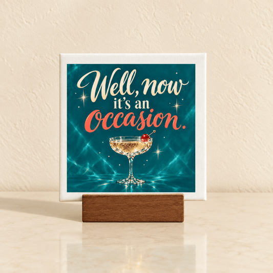 A Well, Now It’s an Occasion Mini Bar Sign in a wooden stand, featuring a square mini canvas with a champagne coupe and cherry illustration.