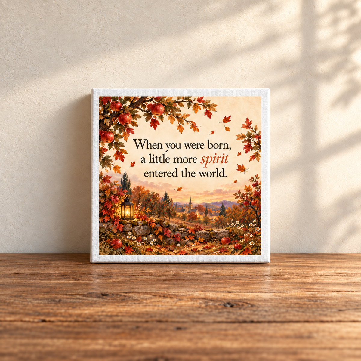 A Little More Spirit Nursery Keepsake Canvas by Mirabilia Boutique features autumn scenery and flowers on a wooden table, with sunlight casting shadows on the wall behind.