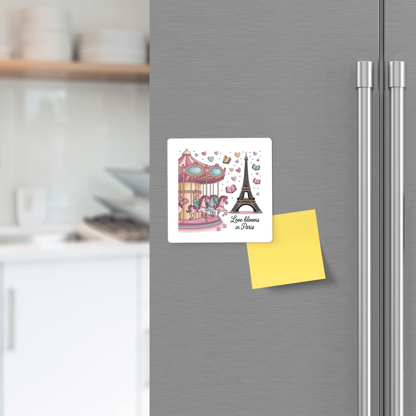 A refrigerator door displays the Mirabilia Boutique "Love Blooms in Paris Magnet – Whimsy & Romance," featuring a carousel and Eiffel Tower, with a yellow sticky note below and subtle Parisian decor in the background.