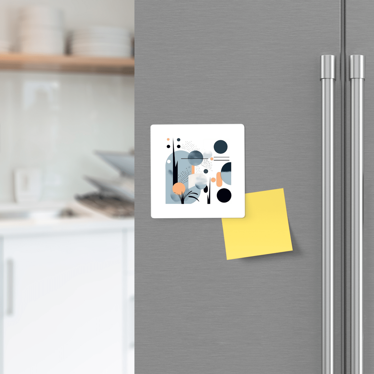A stainless steel refrigerator door displays the Mirabilia Boutique Coastal Sunrise Mid Century Modern Magnet and a yellow sticky note, with blurred kitchen shelves holding dishes in the background.