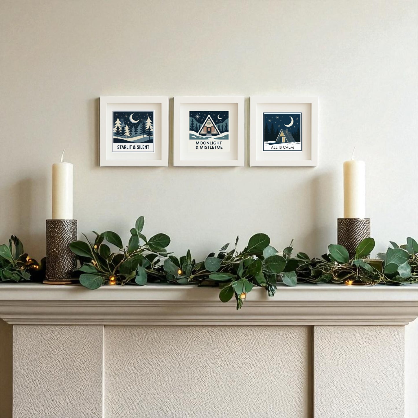 A mantel adorned with green foliage, lights, and candles sits below the Mirabilia Boutique Winter Mid-Century Art Trio—cozy holiday wall decor featuring minimalist seasonal designs and winter night scenes.