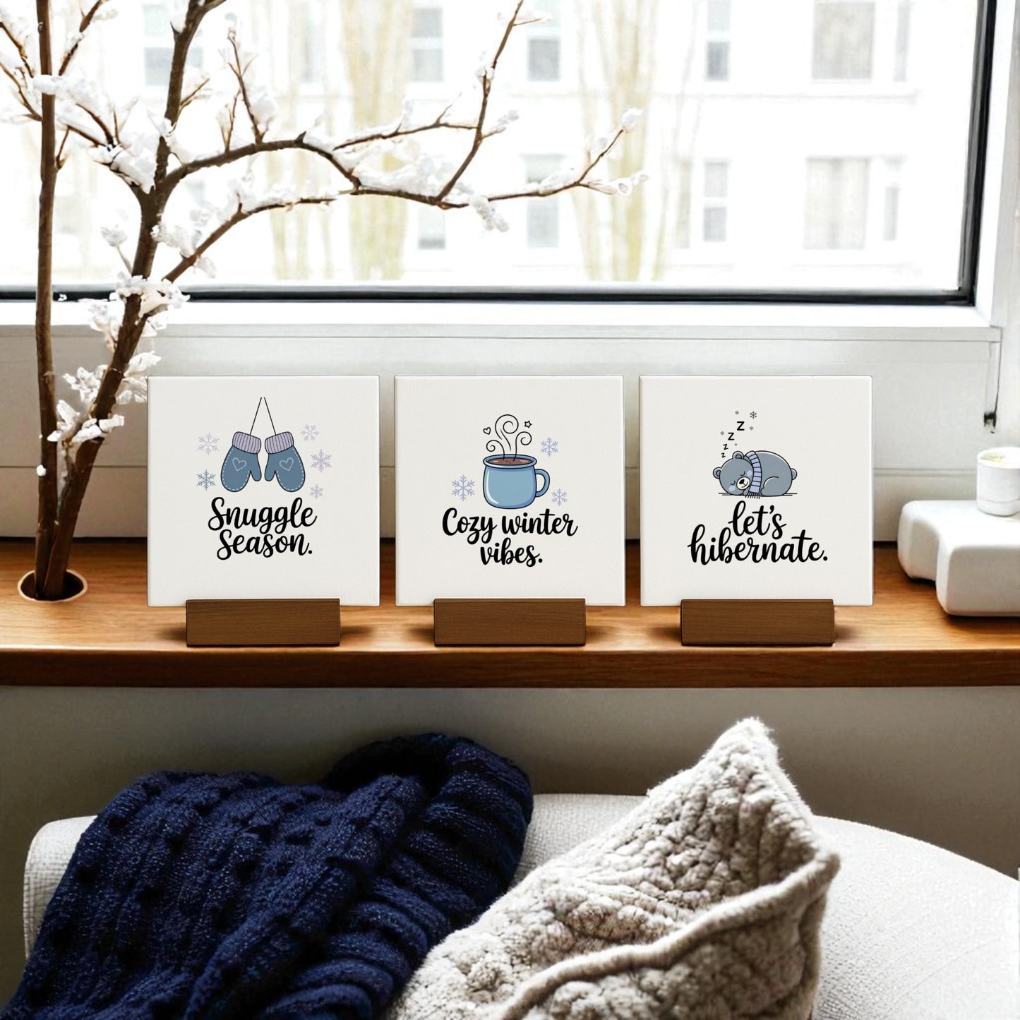 The Winter Canvas Sign Trio by Mirabilia Boutique features “Snuggle,” “Cozy Vibes,” and “Hibernate” designs—perfect for adding charming, cozy winter decor to your space or gifting as a winter set. Blanket and branch accents complete the look.