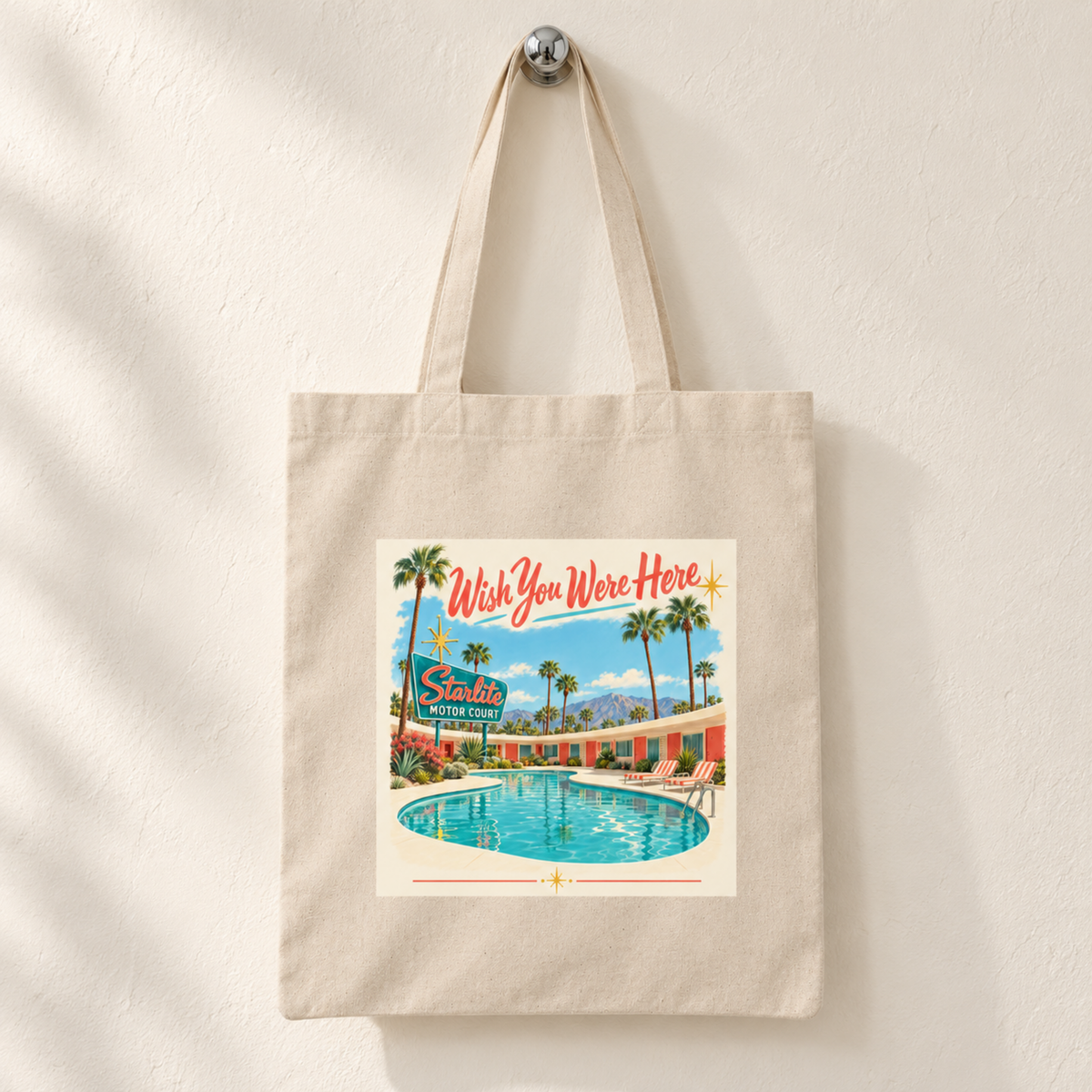 Wish You Were Here Tote | Chrome & Starlight canvas bag featuring a mid-century postcard illustration of a motel pool with a “Starlite Motor Court” sign and the text “Wish You Were Here.”.