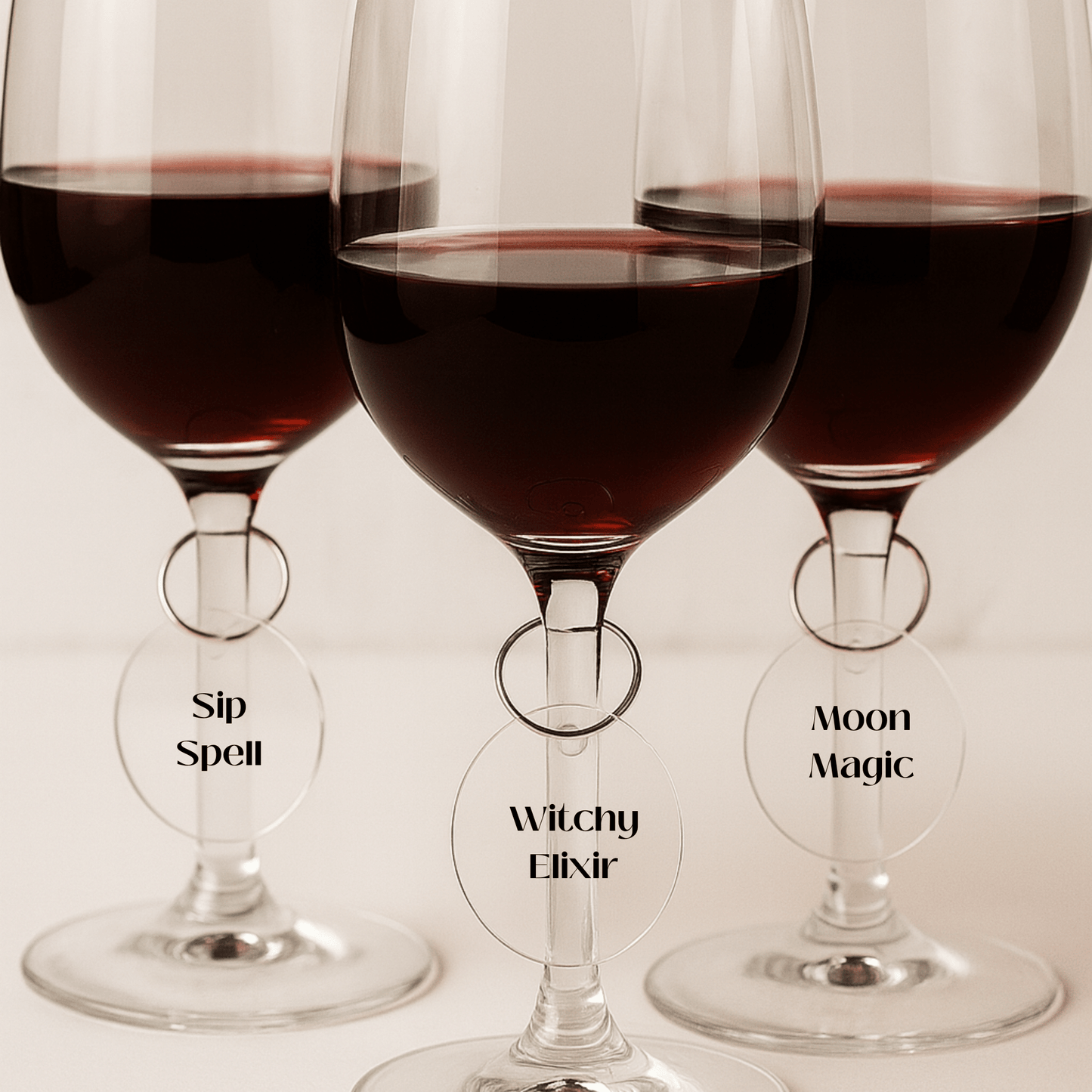 Add a magical touch to your table with the Witchy Wine Charms Set | Halloween Glass Tags by Mirabilia Boutique—each glass tag reads "Sip Spell," "Witchy Elixir," or "Moon Magic" for enchanting Halloween vibes.