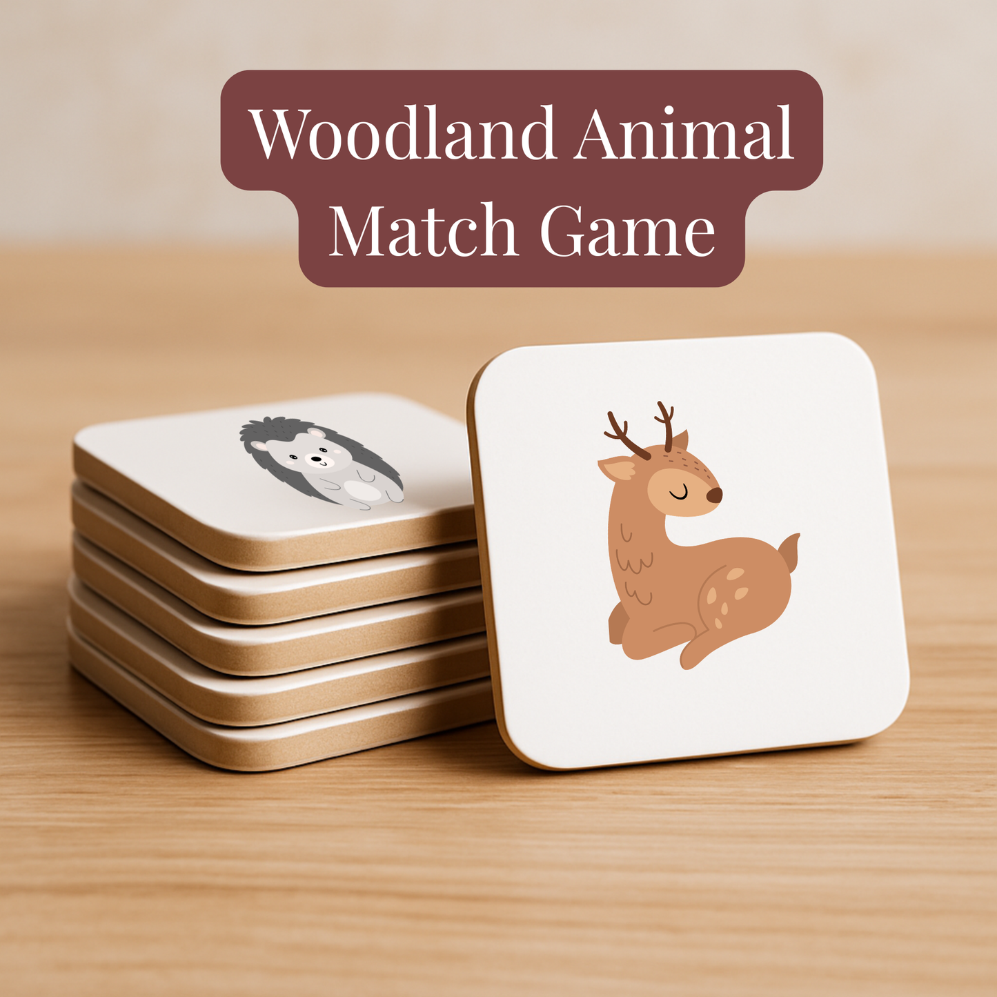 A stack of square cards illustrated with deer and hedgehog rests on a wooden surface beneath the text “Woodland Animal Match Game | Kids Memory Game | 15 Pairs” by Mirabilia Boutique—perfect for preschool activities.