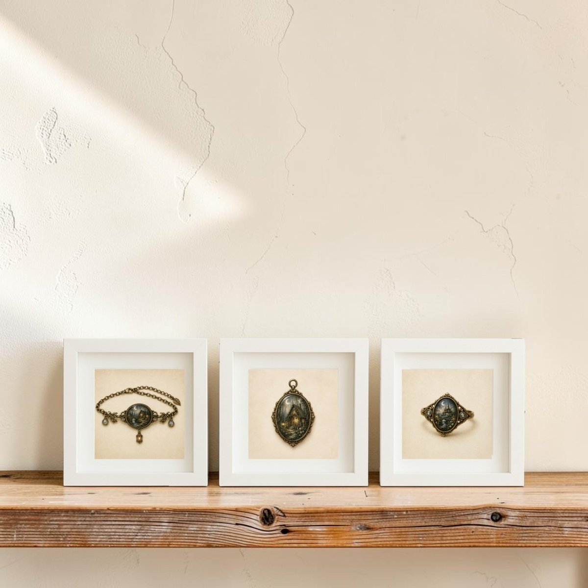 Three framed vintage jewelry pieces from Mirabilia Boutique’s The Woodland Reliquary | Mirabilia Relics Trio are displayed in white shadow boxes on a rustic wooden shelf against a textured cream-colored wall with soft sunlight.