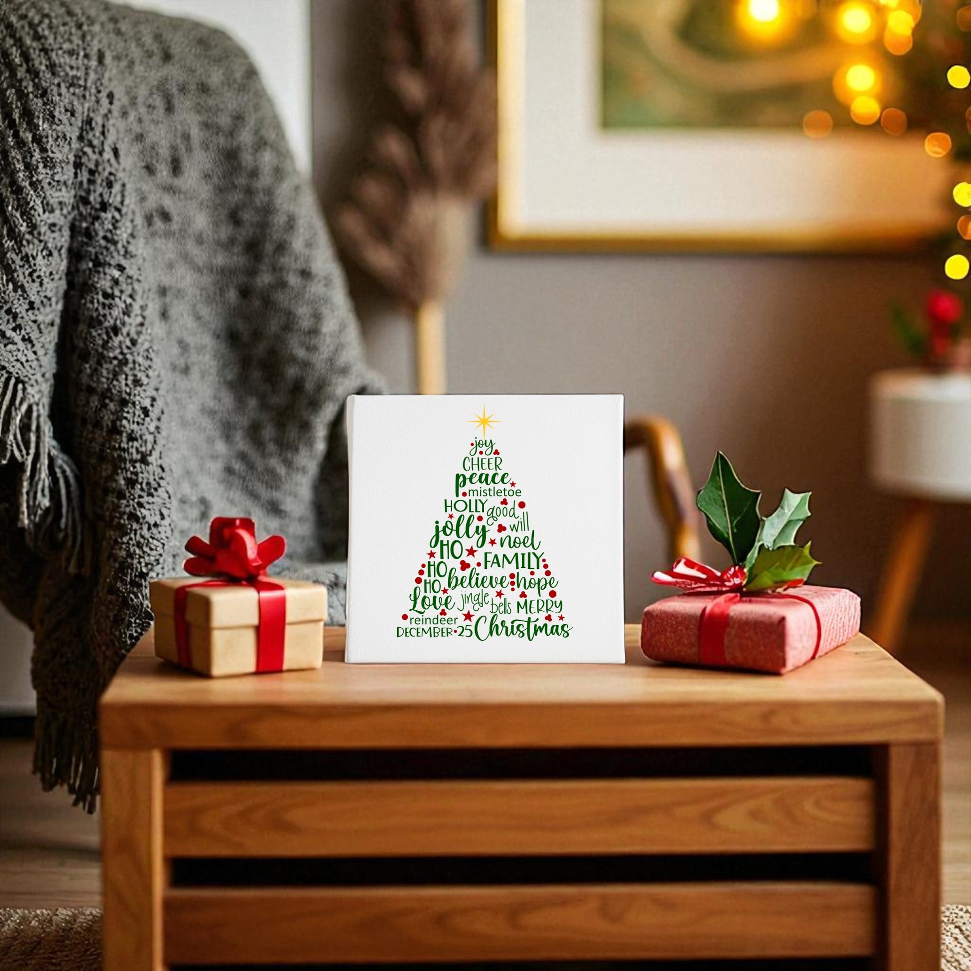 A cozy living room features a wooden table with two wrapped gifts and a Christmas card showcasing the Word Art Christmas Tree Canvas (8x8 Holiday Decor) by Mirabilia Boutique. Festive decor, a chair, and a lit tree appear in the background.