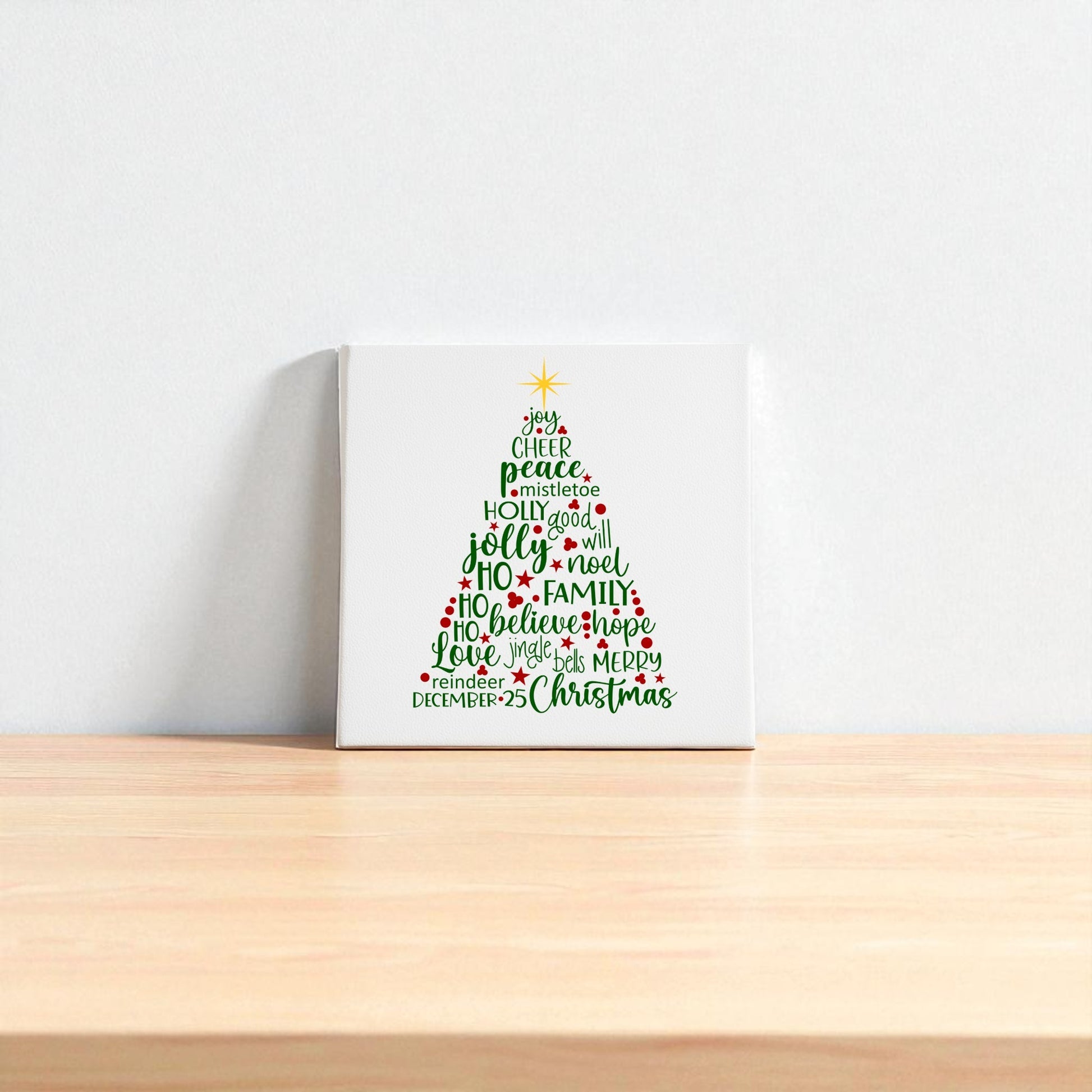 The Word Art Christmas Tree Canvas by Mirabilia Boutique features festive words in red and green forming a tree with a yellow star, adding holiday charm to your space. Available as 8x8 holiday decor, it's perfect for brightening up any room.